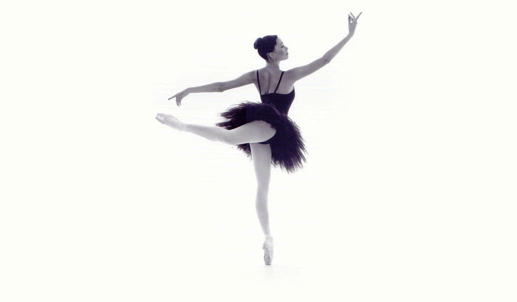Enthralling Black and White Image of Ballerina in Arabesque Pose Wallpaper