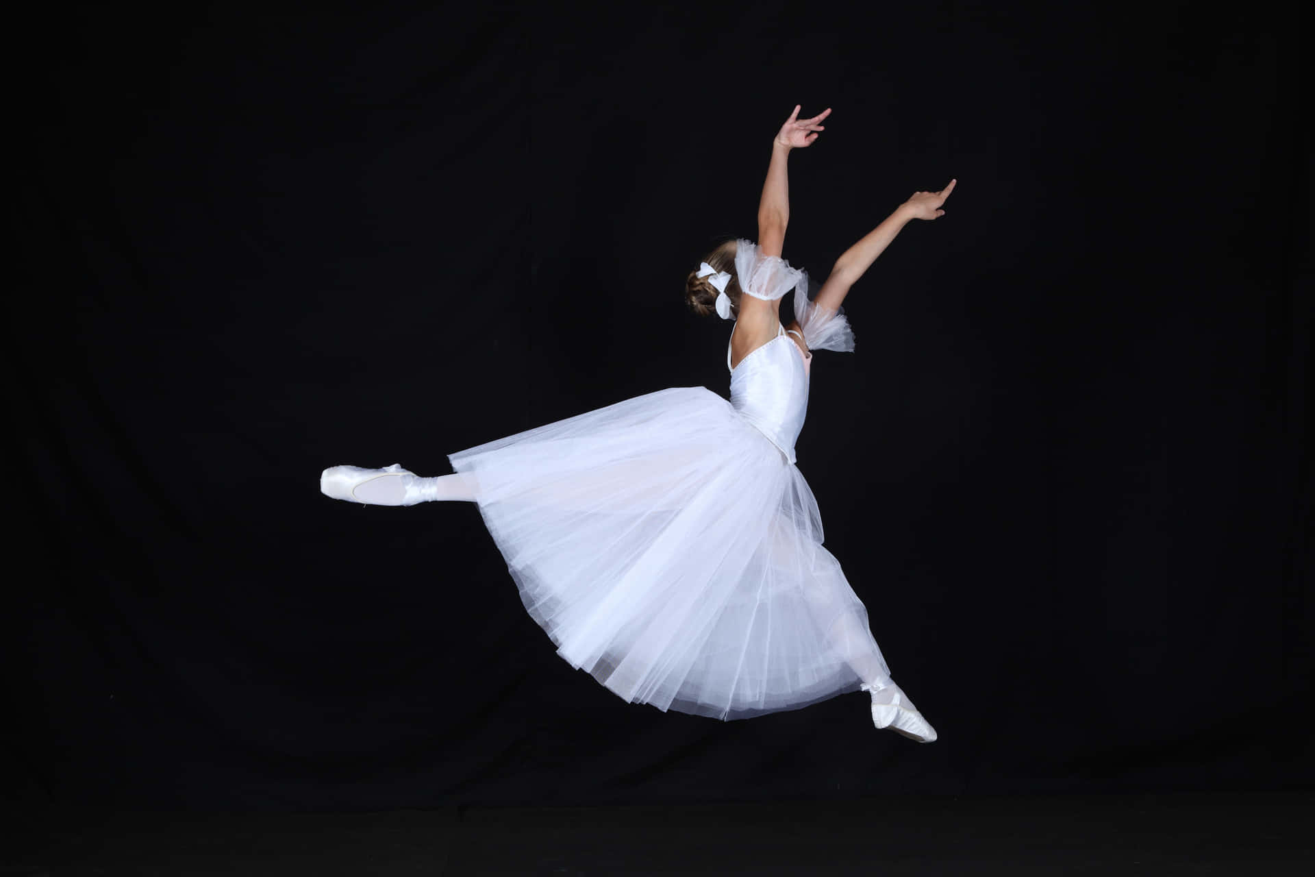 A Young Girl In White Ballet Dress Is Jumping