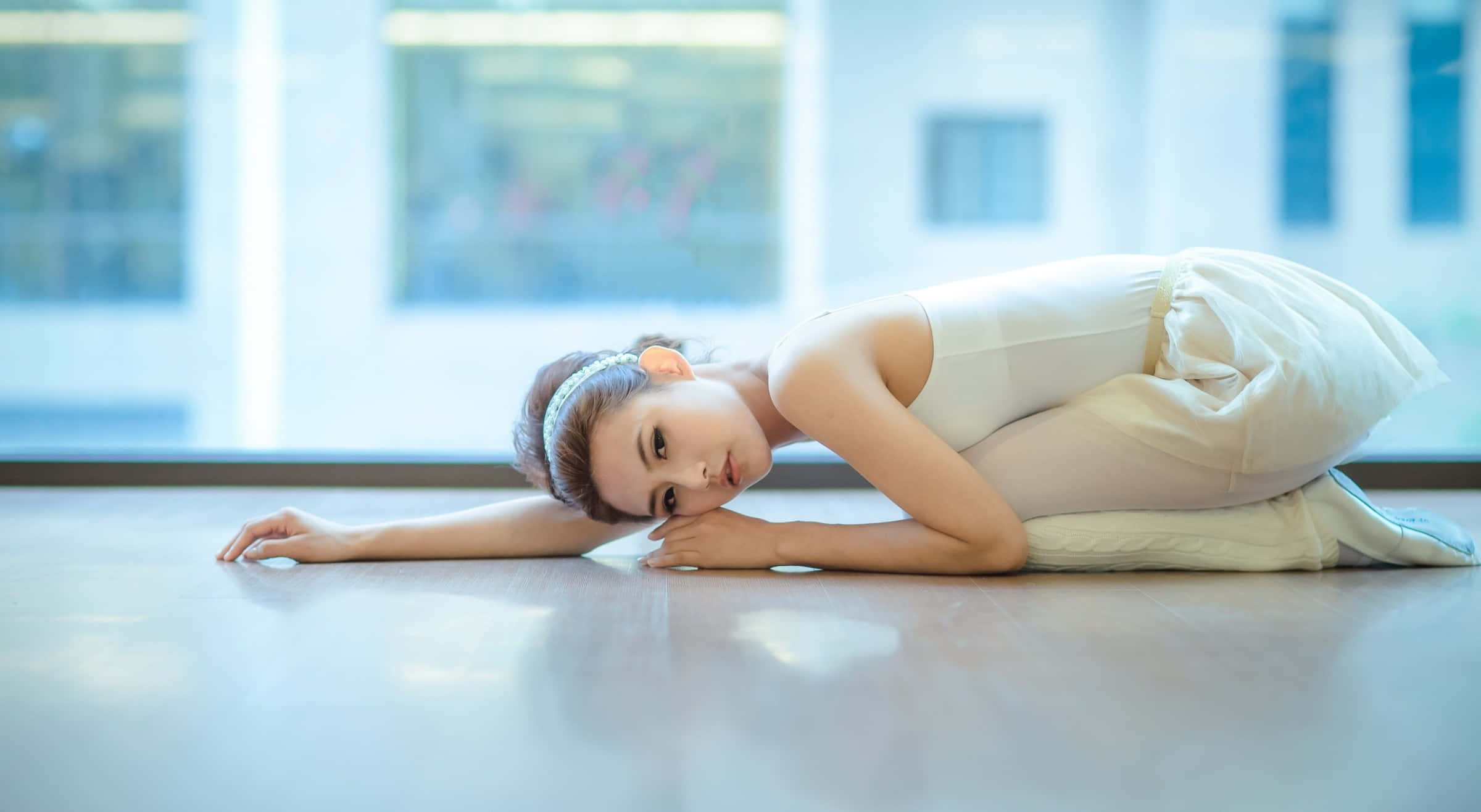 A Young Woman In White Is Laying On The Floor