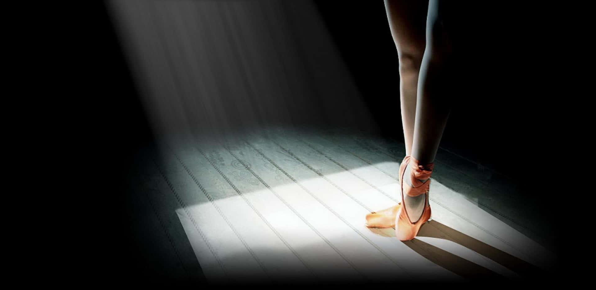 Ballet Dancer En Pointe Spotlight Wallpaper