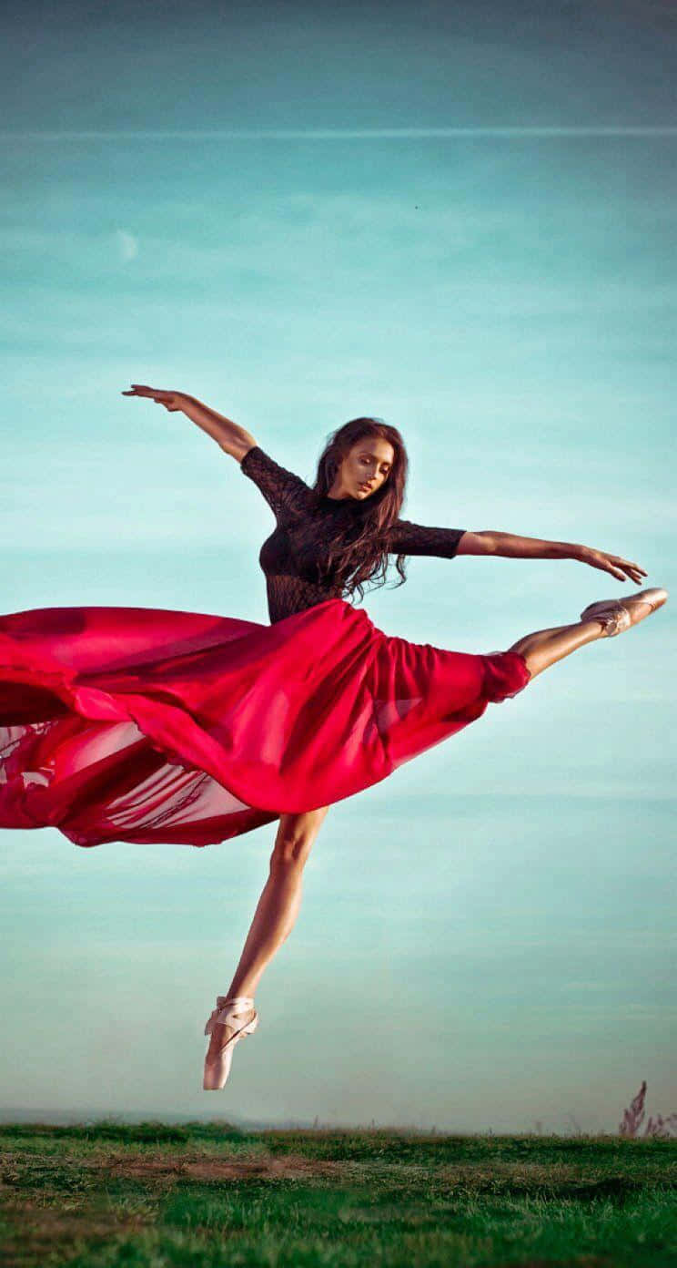 A Woman In A Red Dress Is Jumping In The Air