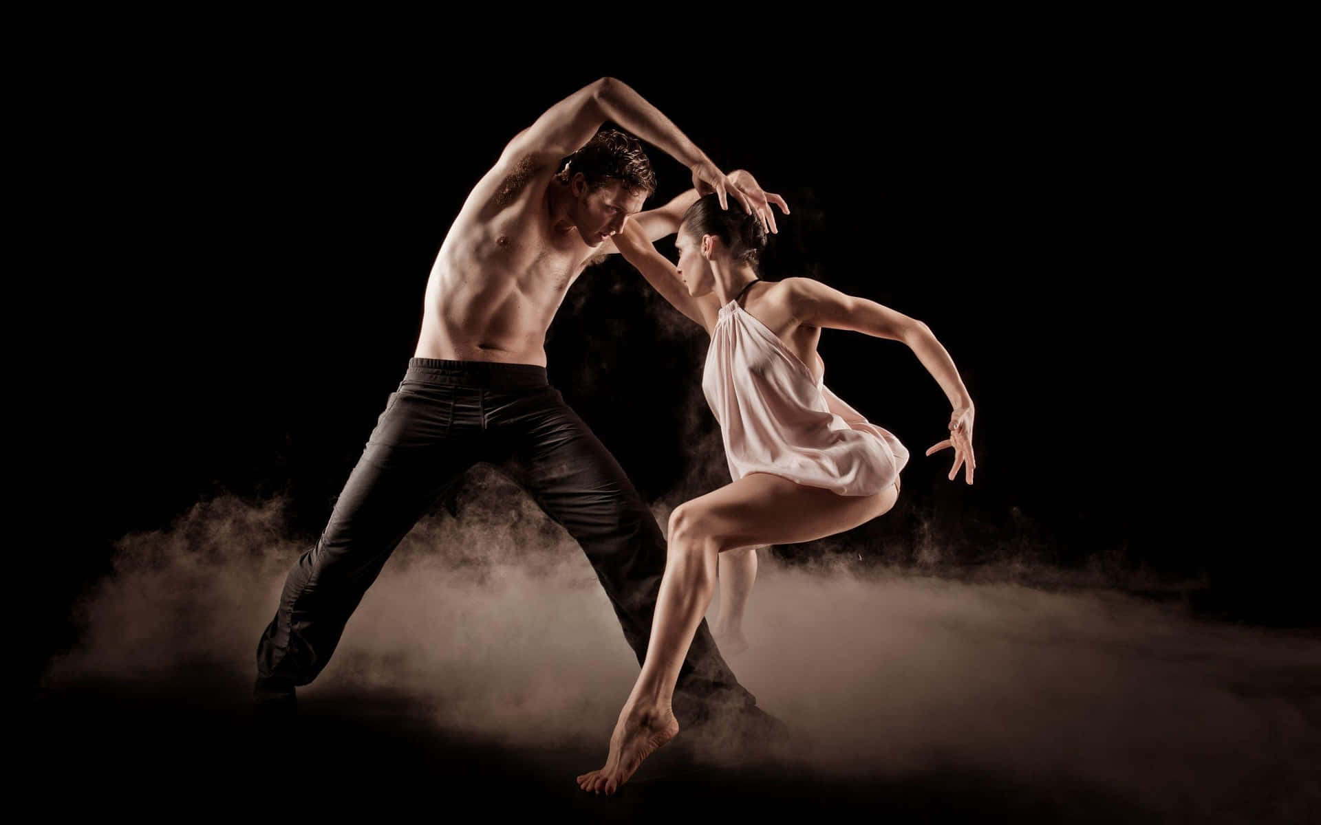 Two Dancers In A Black Background