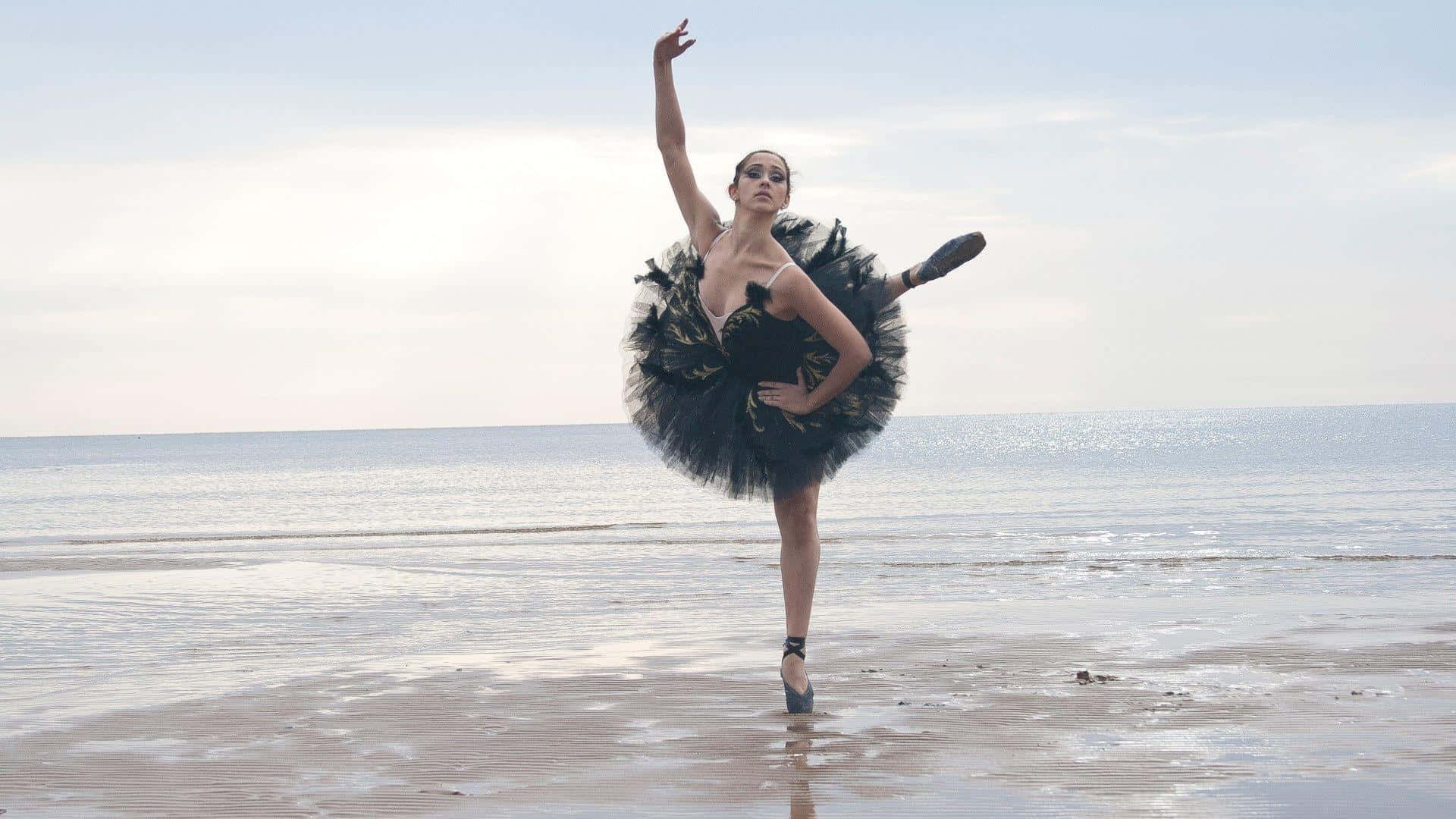 Unadonna In Un Tutù Da Balletto Nero Sta Ballando Sulla Spiaggia