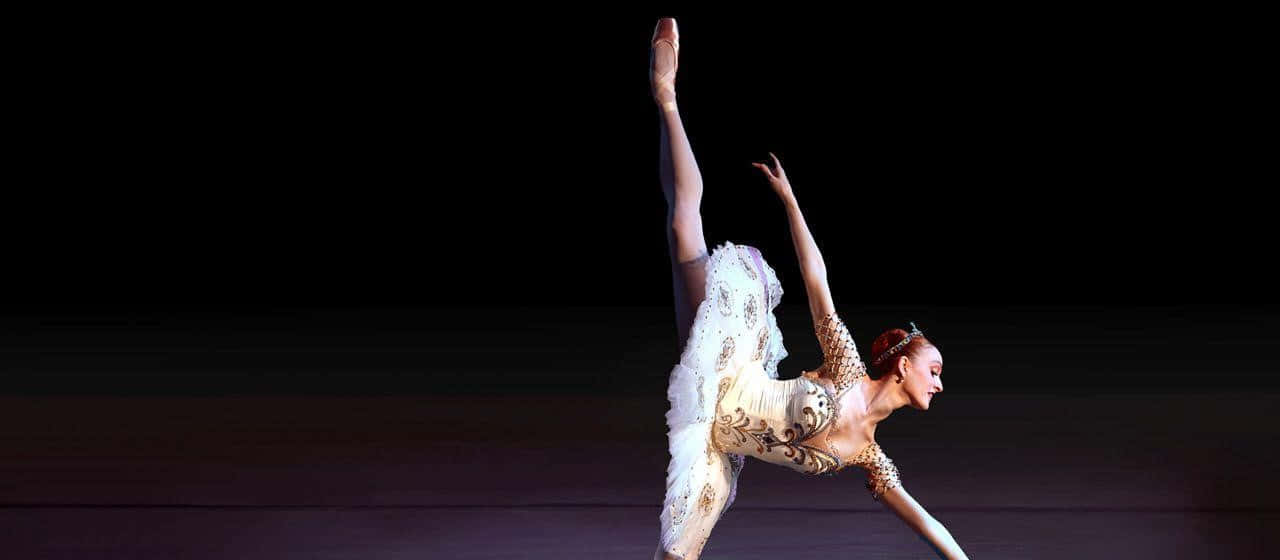 A graceful ballet dancer in her element, captivating an audience with her poise and elegance.