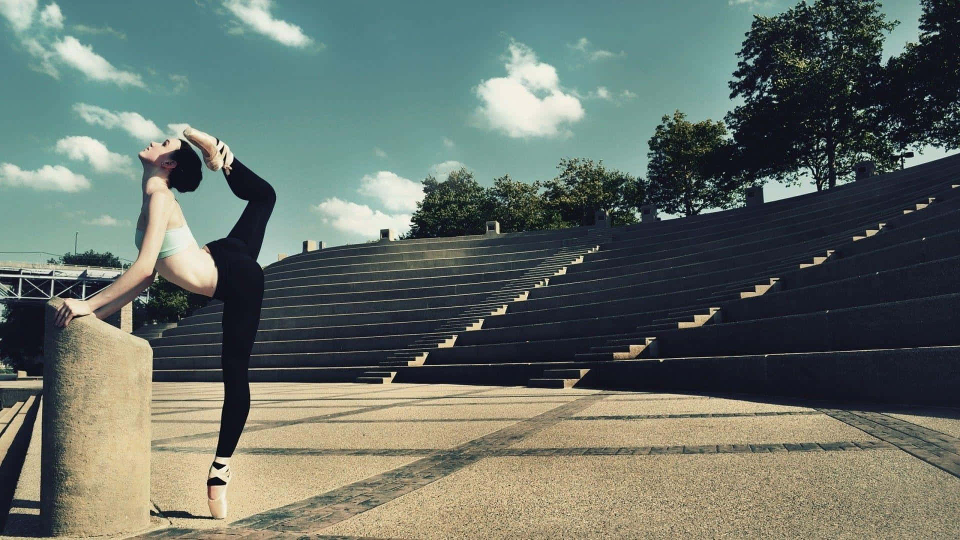 A Woman Is Doing A Ballet Pose On A Set Of Steps