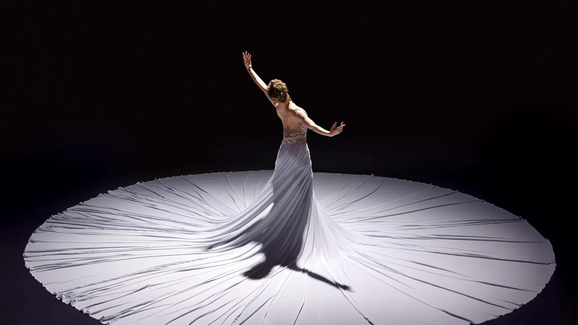 Einefrau In Einem Weißen Kleid Tanzt Auf Einem Weißen Kreis.
