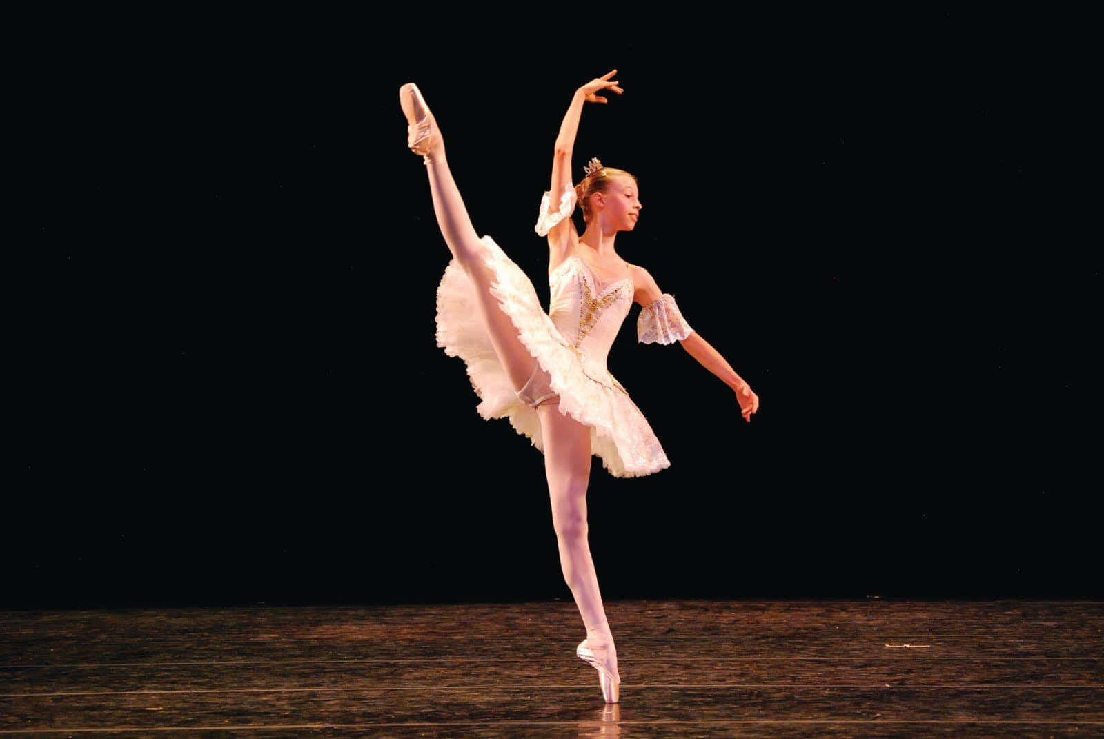 A Young Female Ballet Dancer In White On A Stage