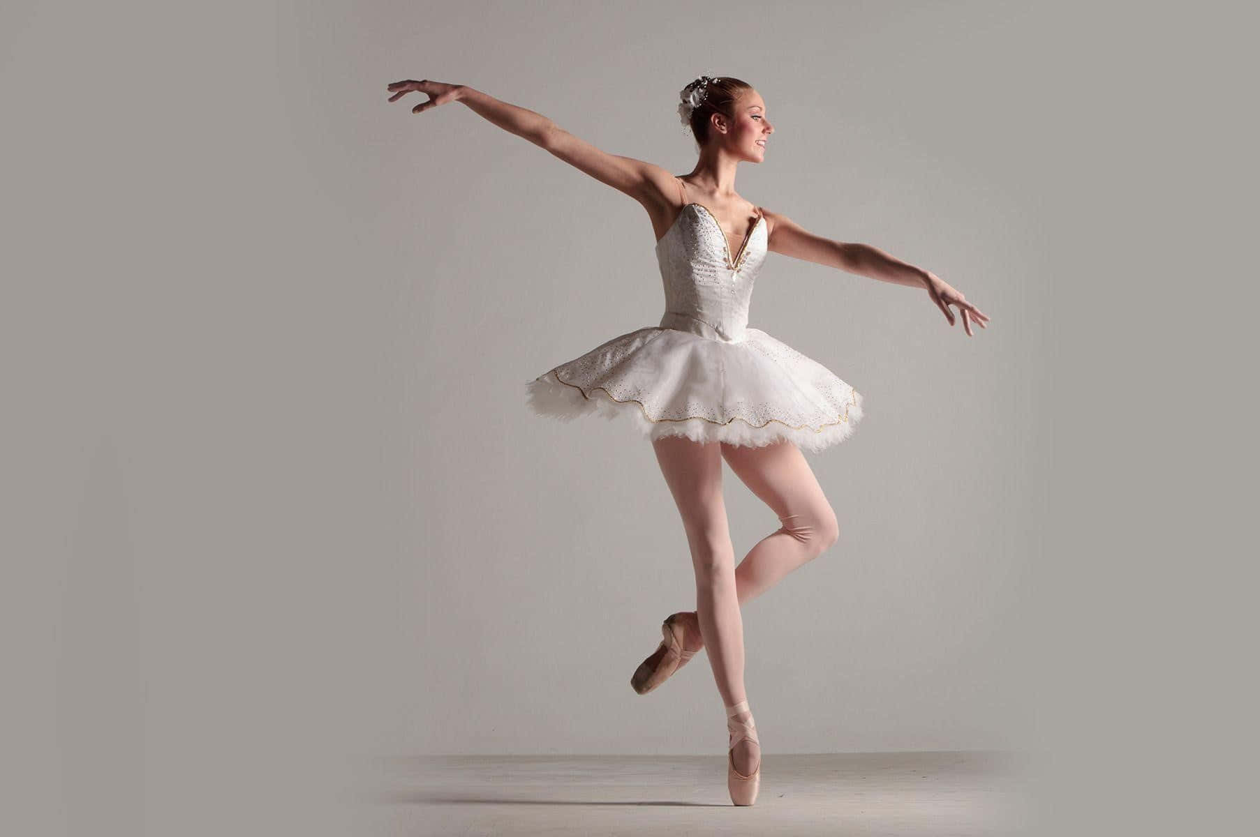 A Young Woman In White Ballet Dress Is Posing