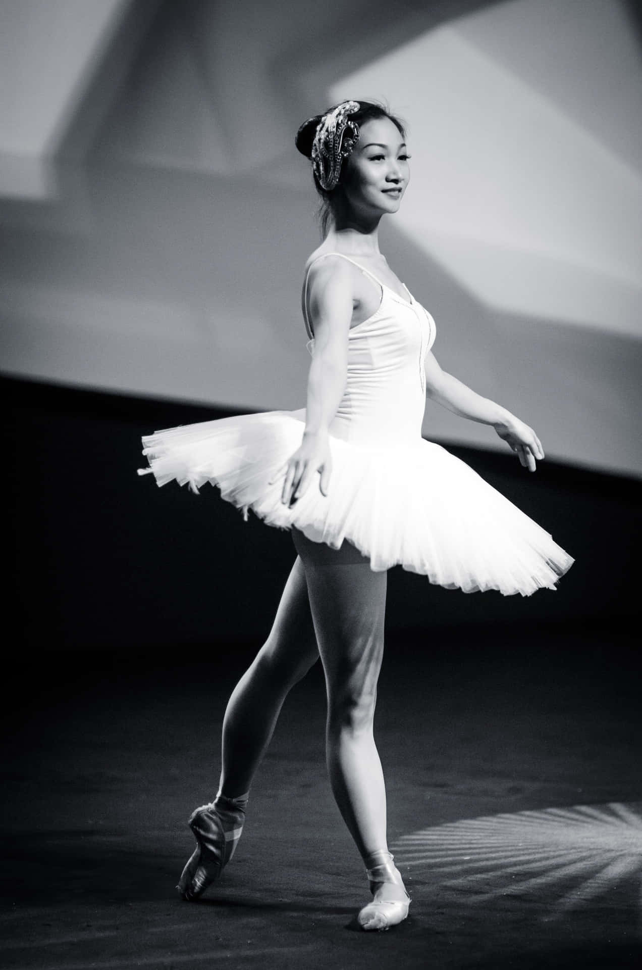 A Young Woman In A White Tutu Is Performing Wallpaper