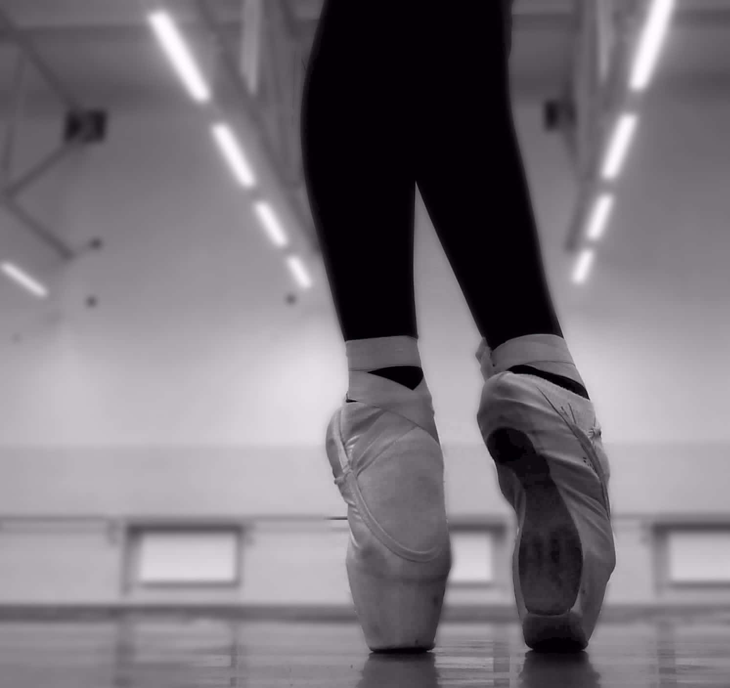 Unabailarina Luciendo Sus Hermosos Zapatos De Ballet De Puntas. Fondo de pantalla