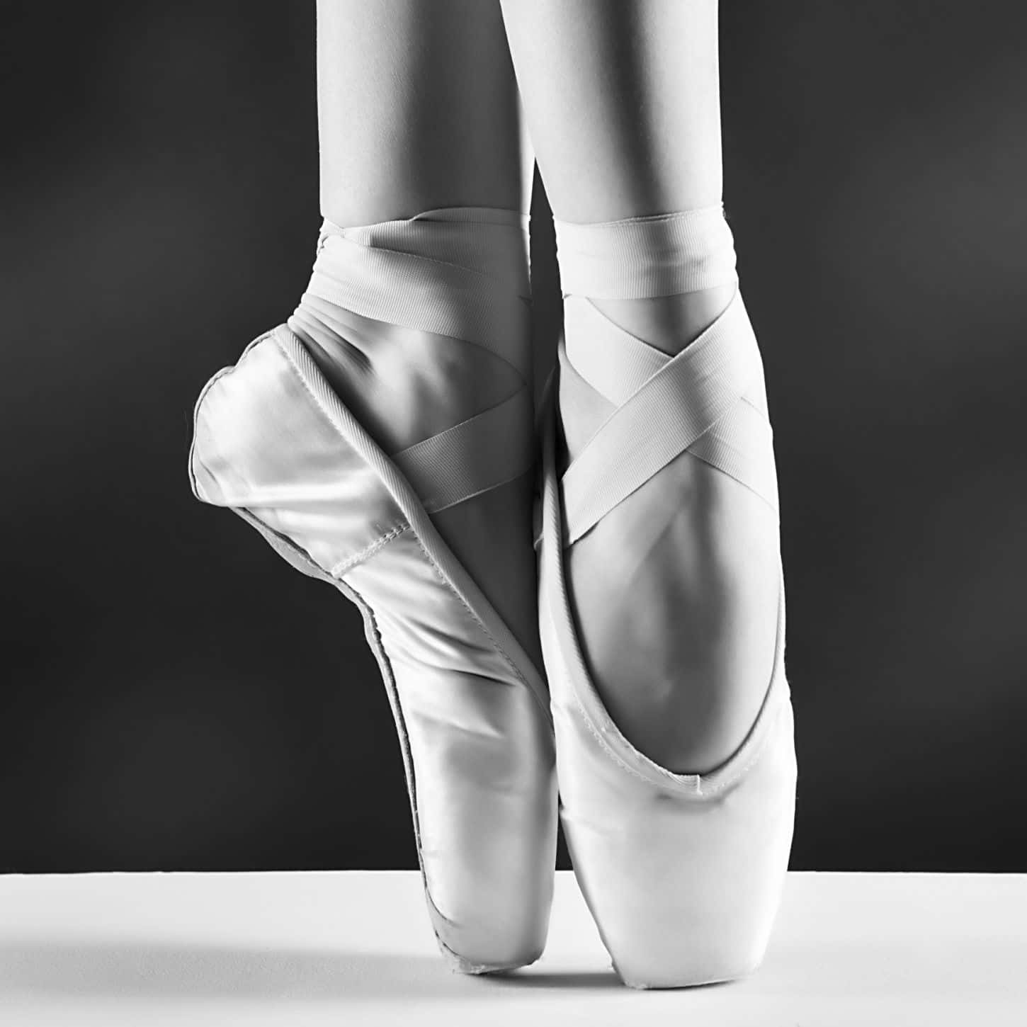 Assapatilhas De Ballet De Uma Mulher São Mostradas Em Preto E Branco. Papel de Parede