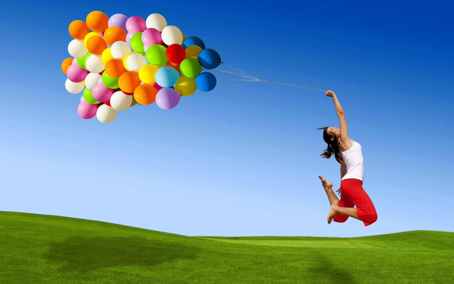 Wallpaper:  Kvinde hopper med balloner tapet.
