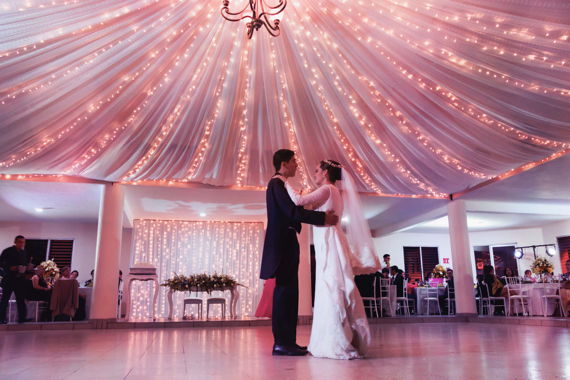 A Bride And Groom Dancing In A Wedding Reception