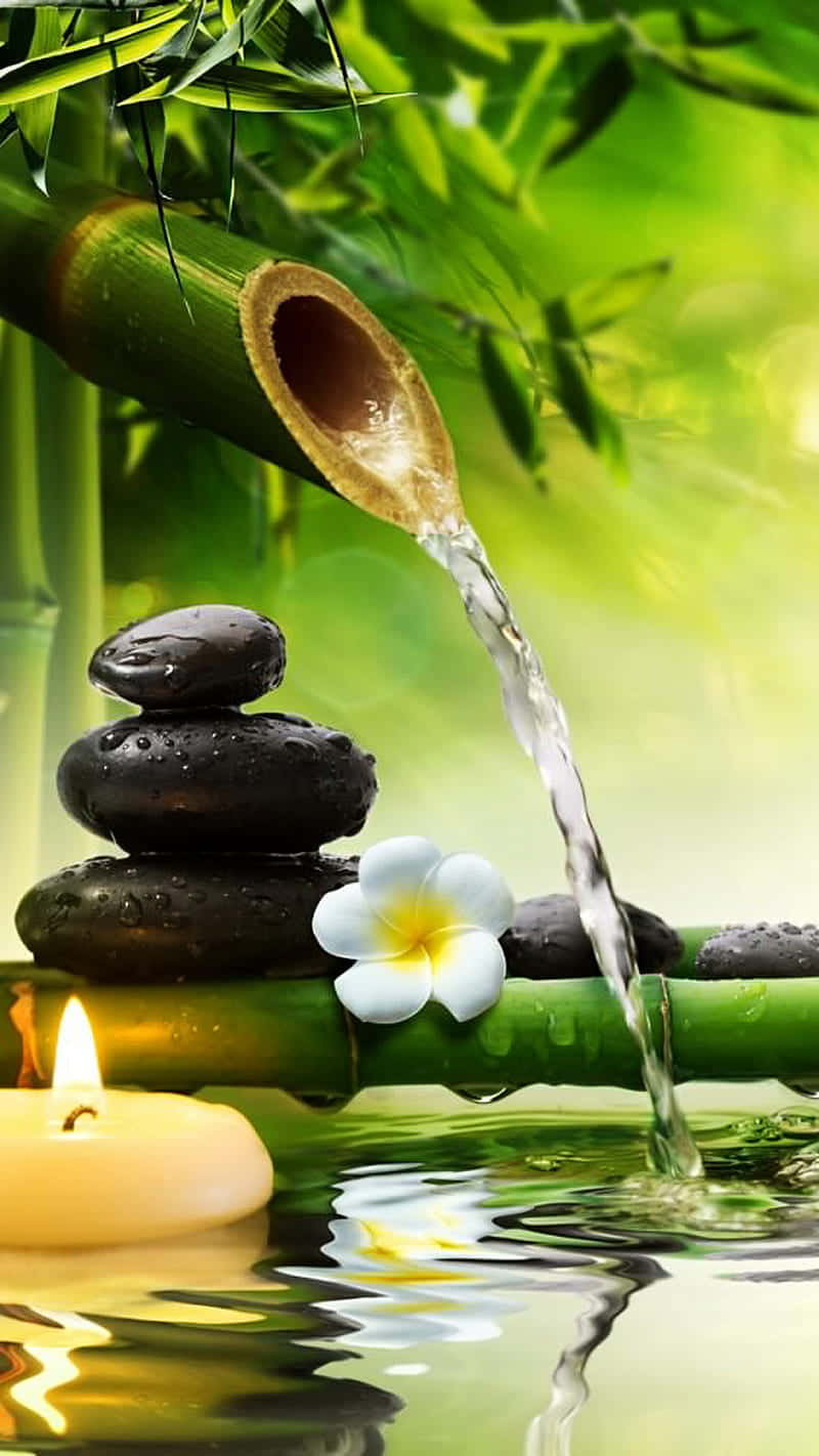 A Bamboo Tree With Water Flowing Over It And Candles Wallpaper