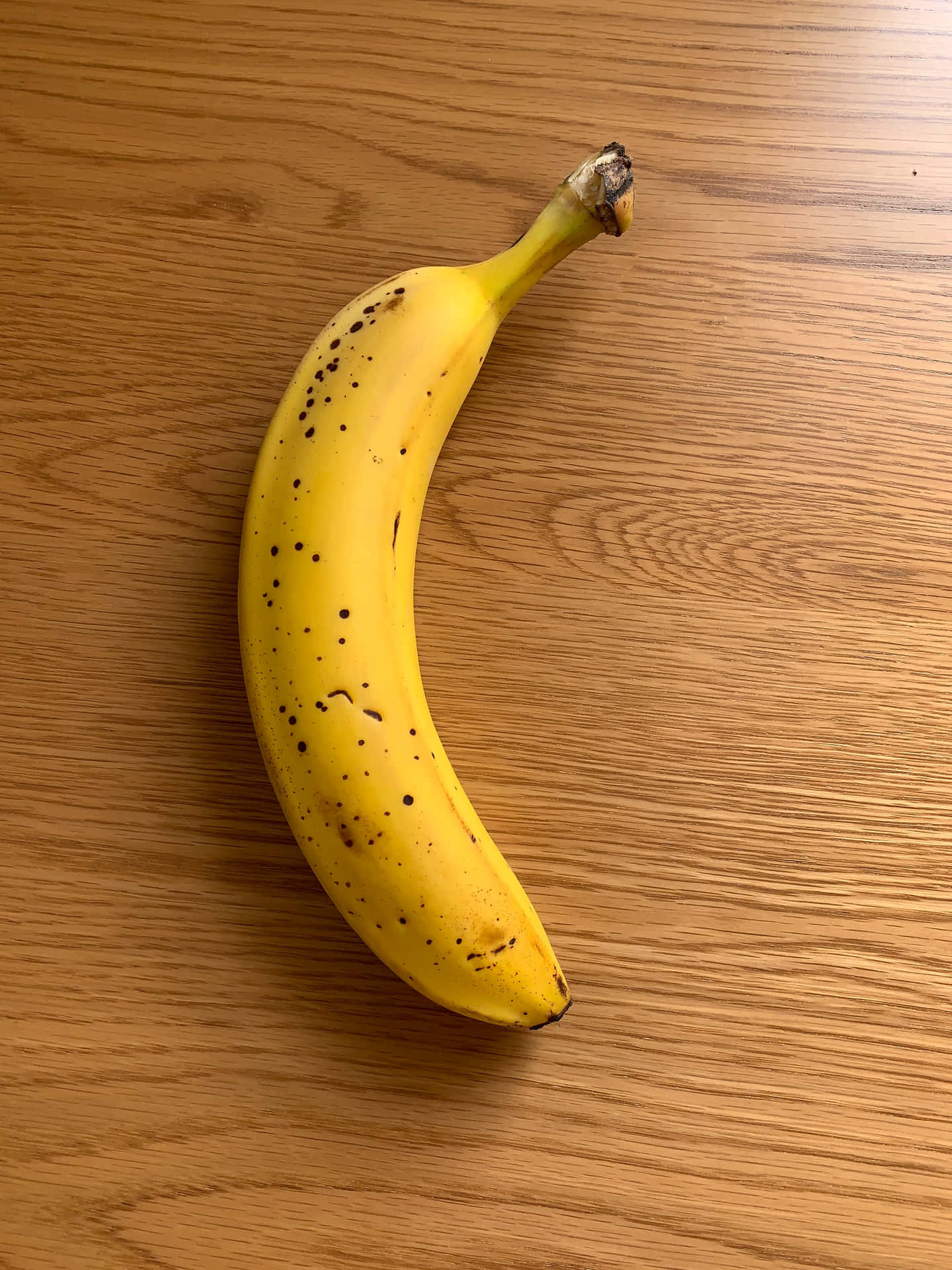 Lysendegule Bananer I Et Farverigt Tropisk Miljø.