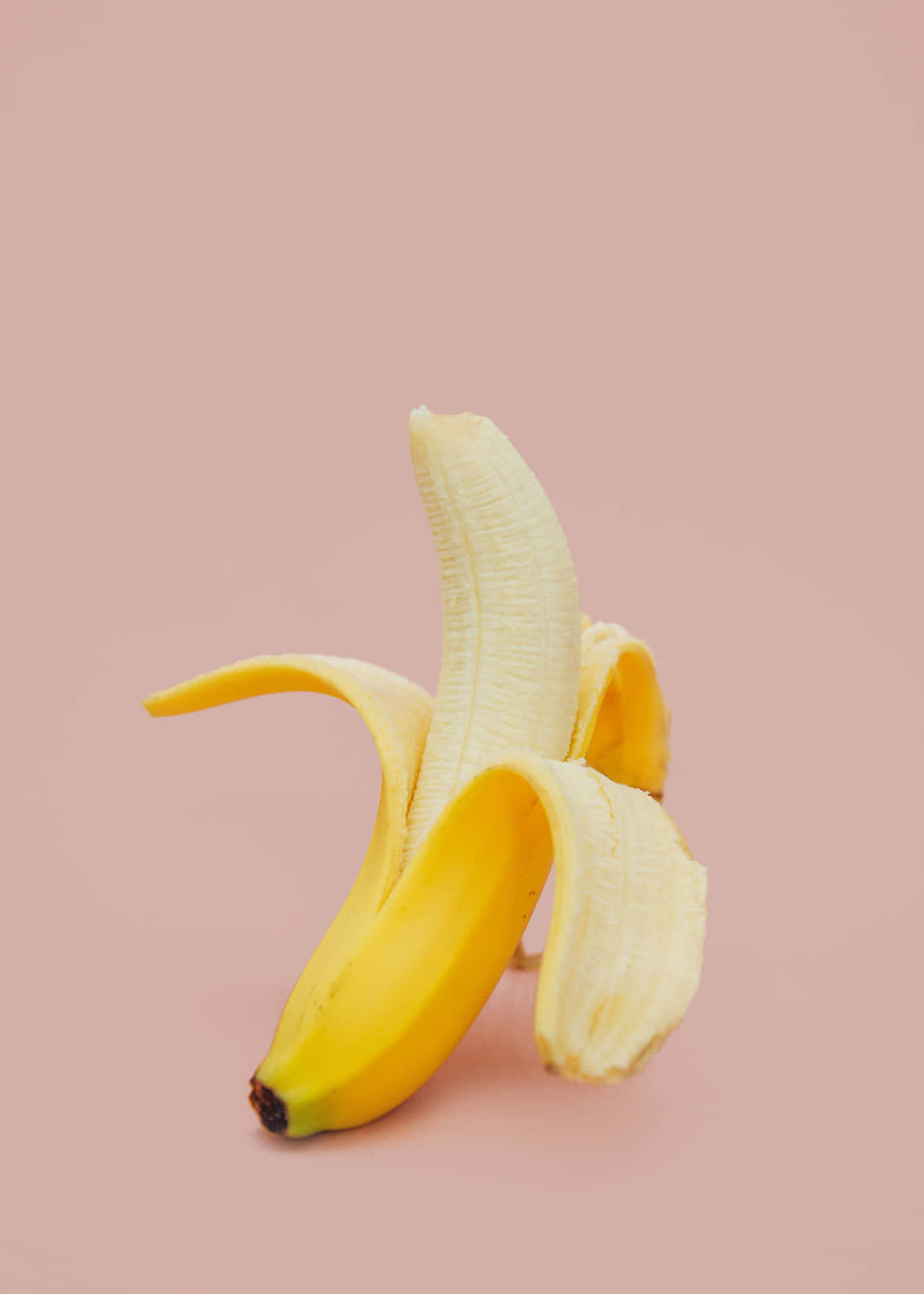 A delicious yellow banana on a white plate.