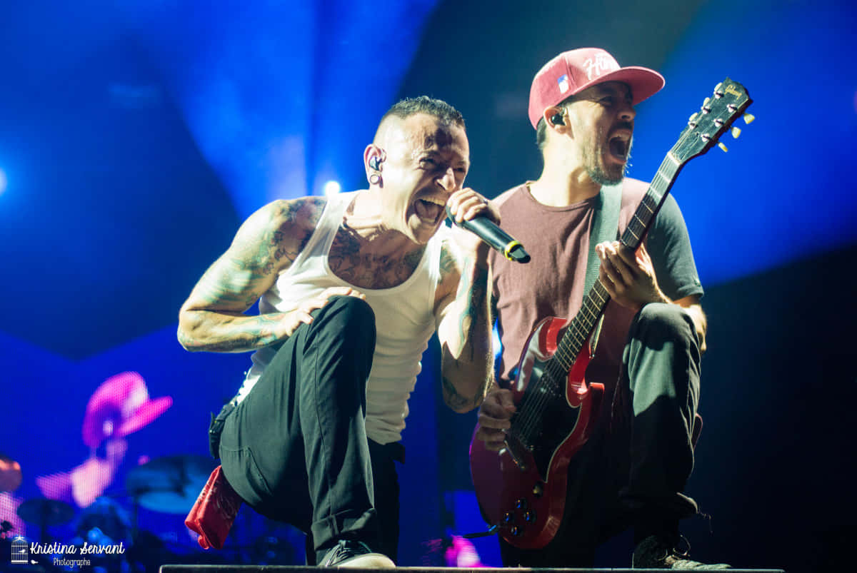 Two Men With Tattoos On Their Arms And Guitars