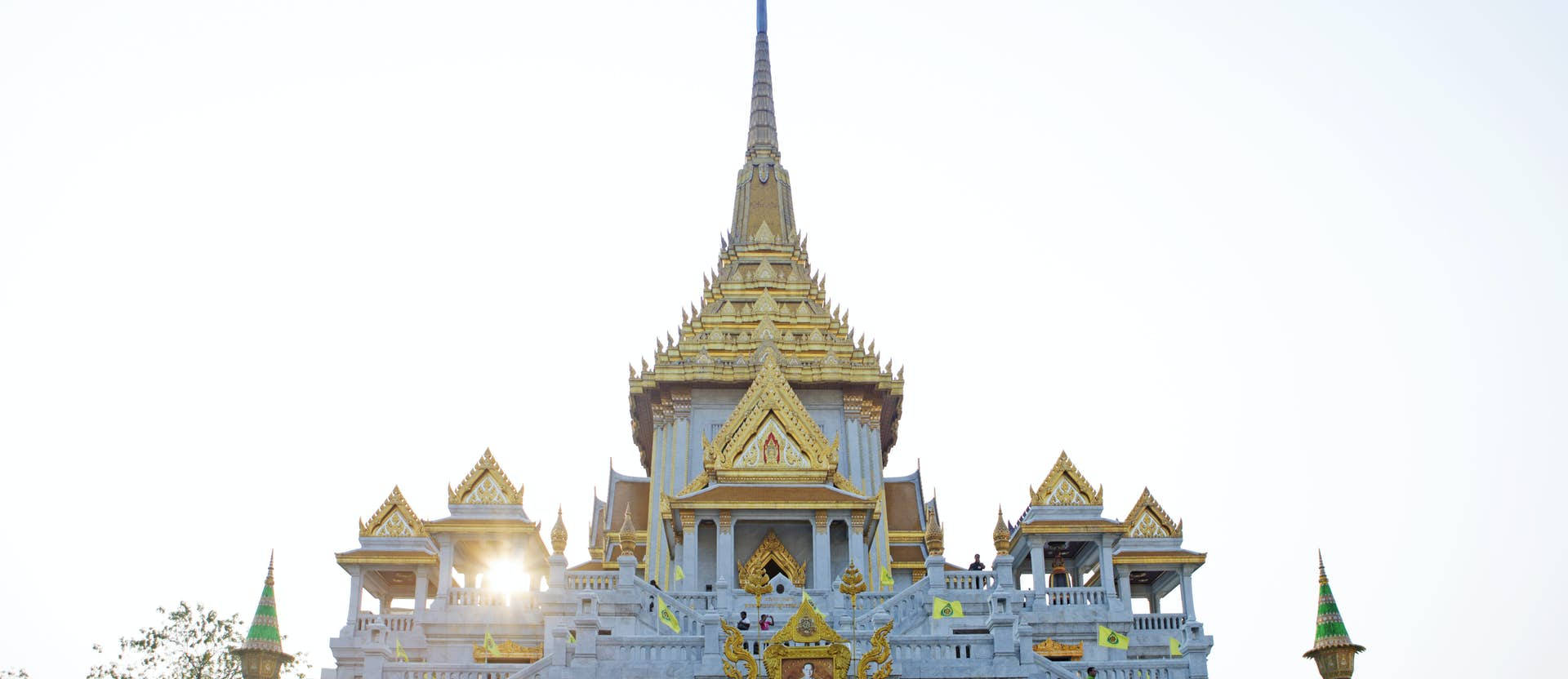 Bangkok's Wat Traimit, dets gyldne Buddha skinnende klokkespil mod en lyseblå baggrund. Wallpaper