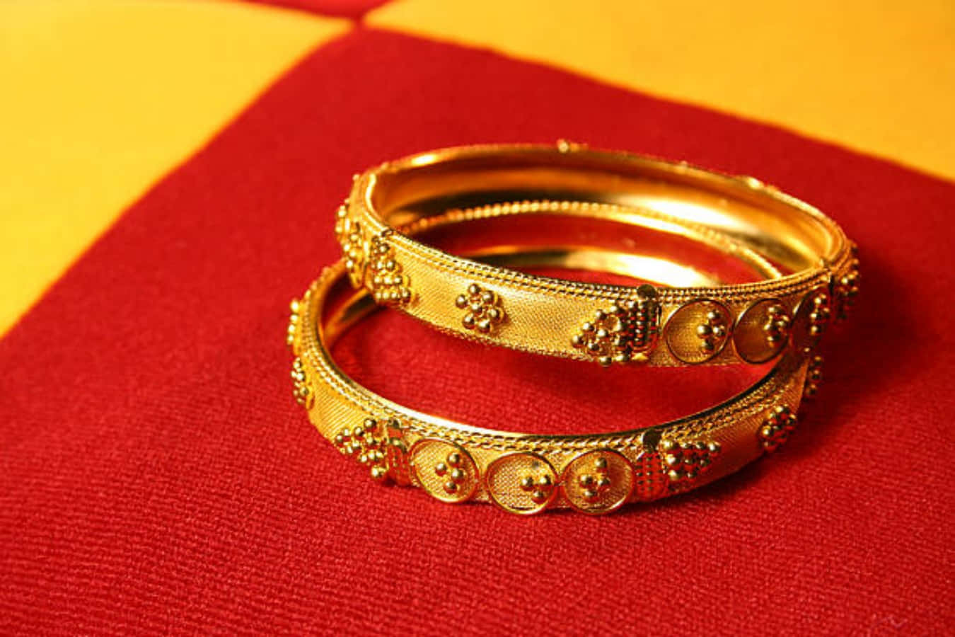 Gold Bangles On A Red And Yellow Cloth