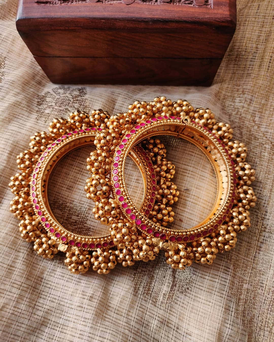 Two Gold Bangles With Red Stones