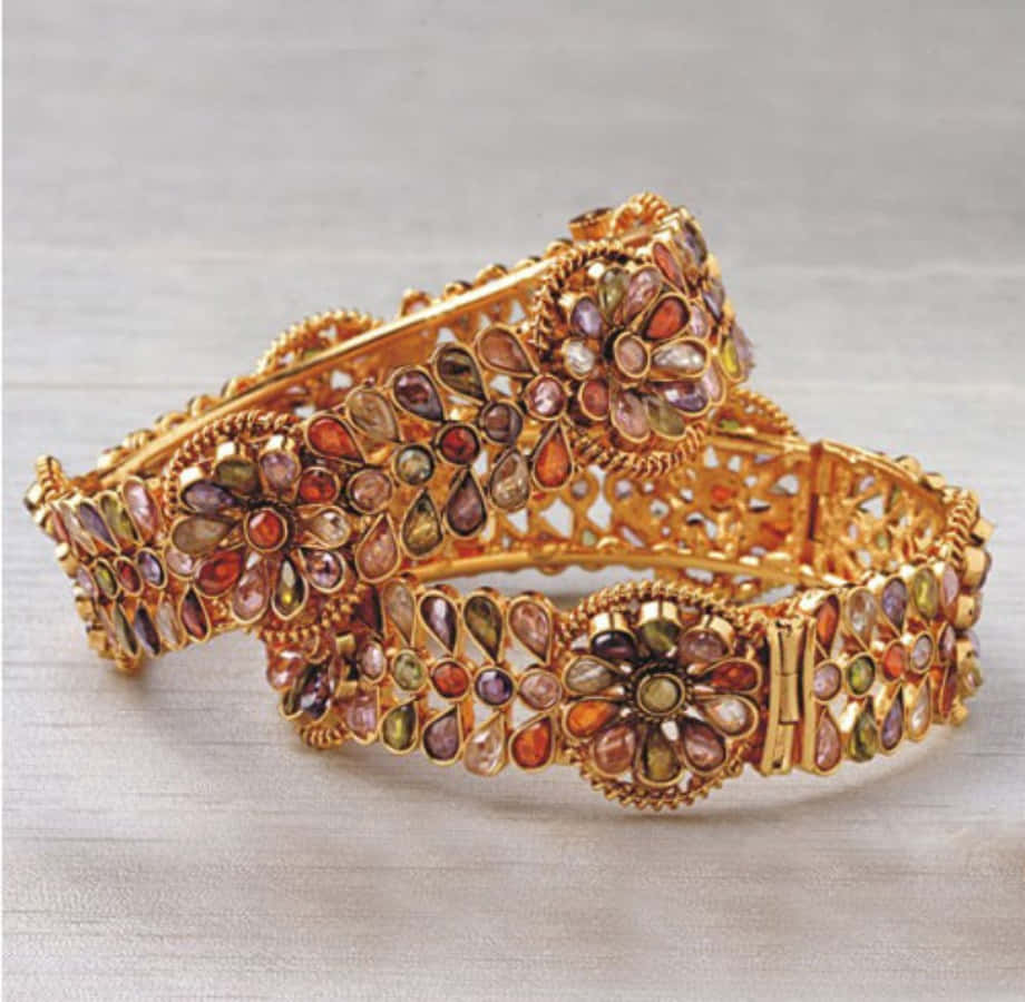 Two Gold Bangles With Stones On Them
