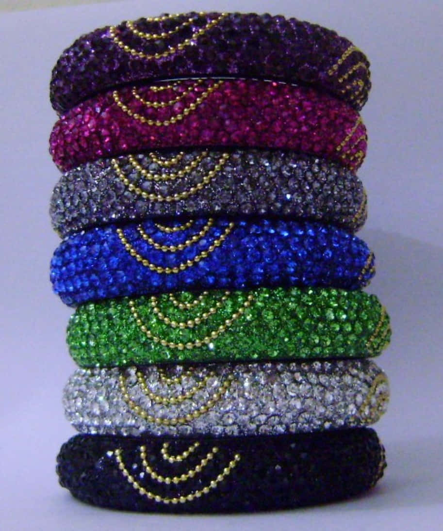 A Stack Of Colorful Bangles With Gold And Silver Beads