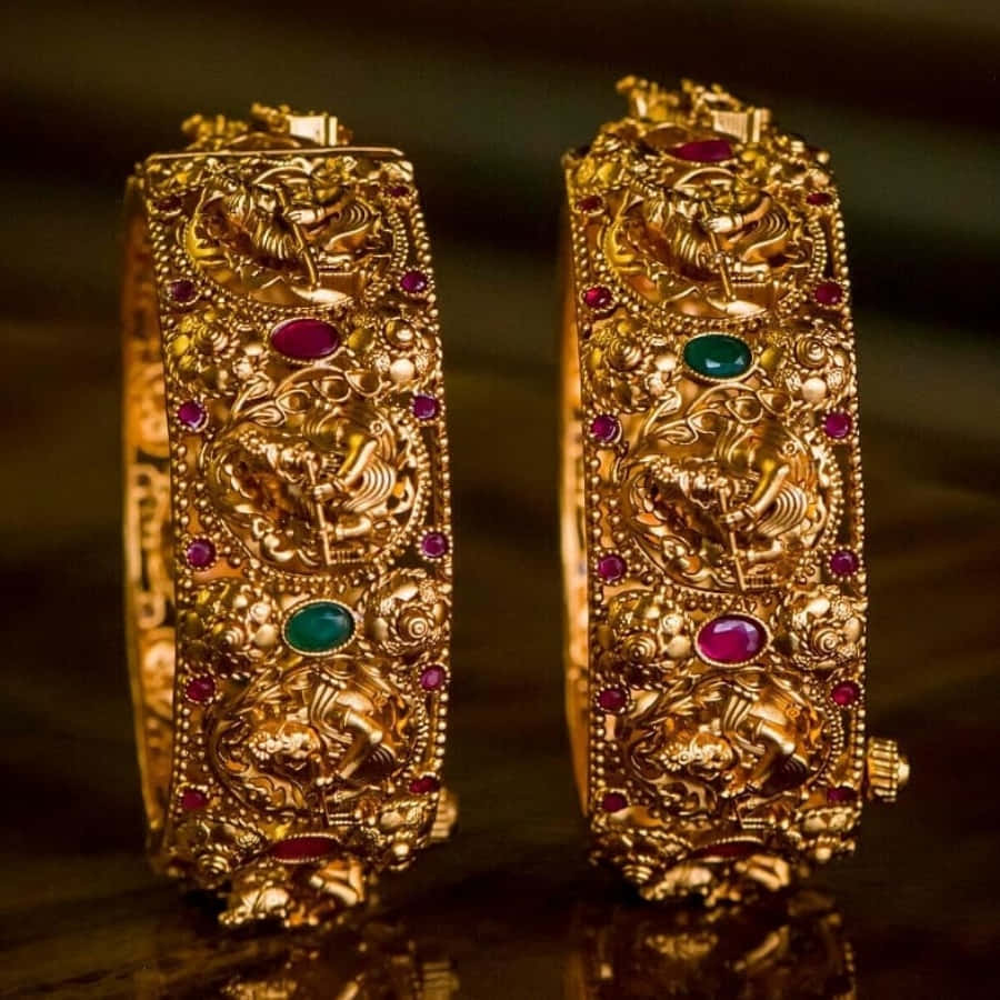 Two Gold Bangles With Emerald Stones