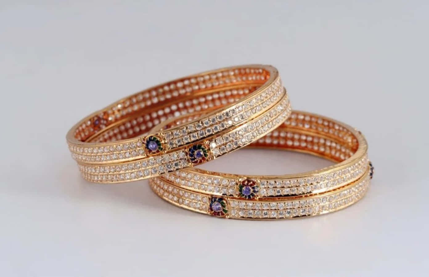 Two Gold Bangles With Purple Stones