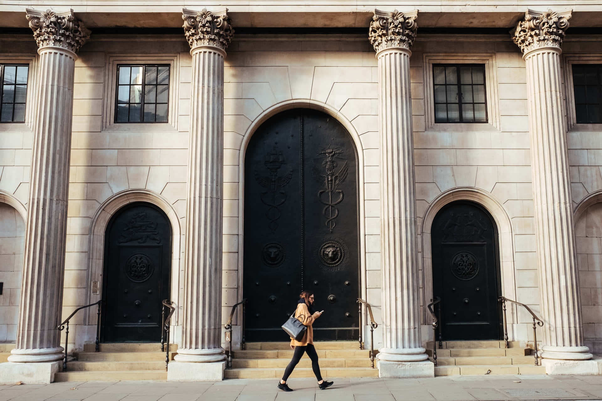 A Woman Walking Down The Steps Of A Building