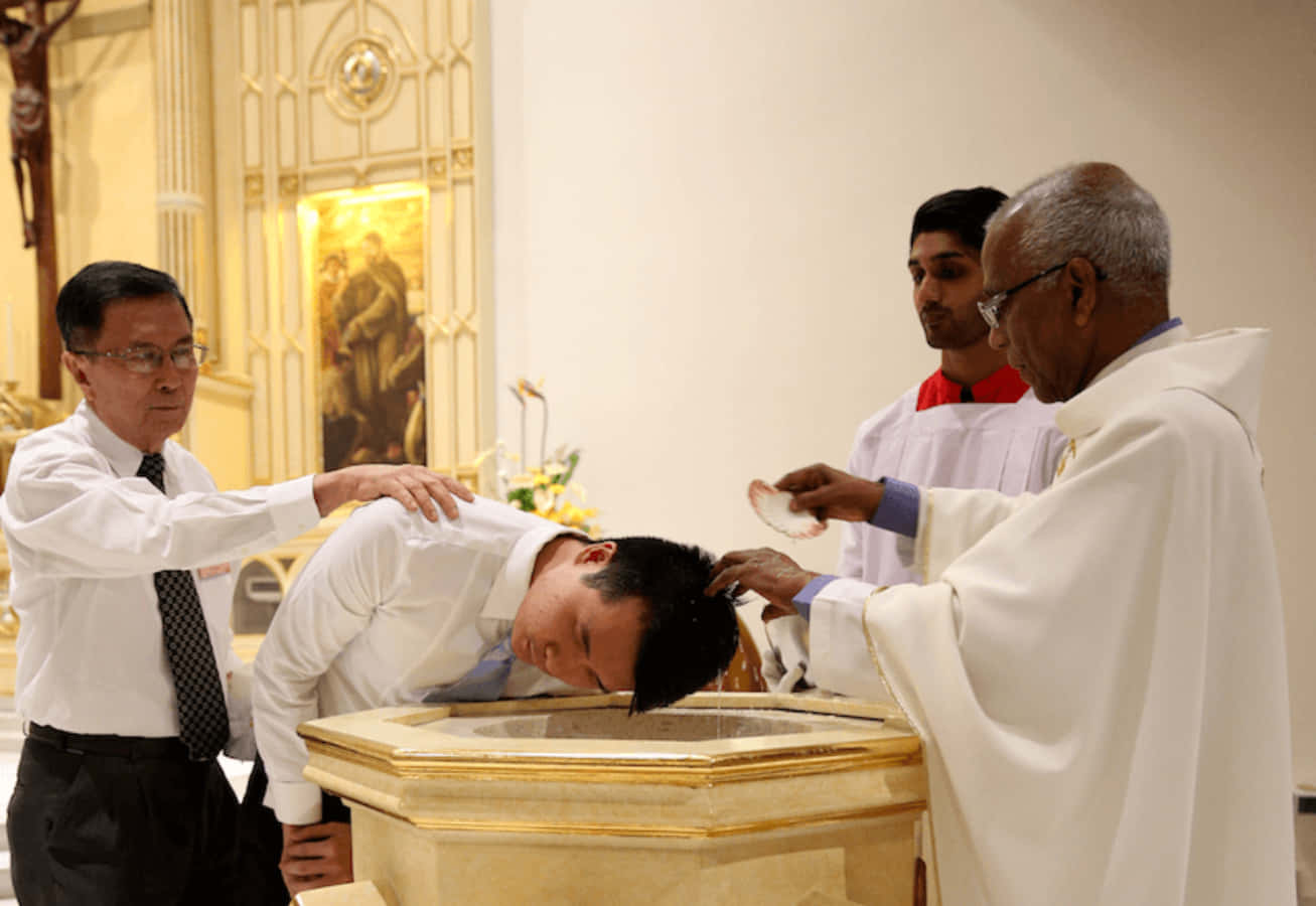 A Priest Is Putting A Man's Hand In A Bowl