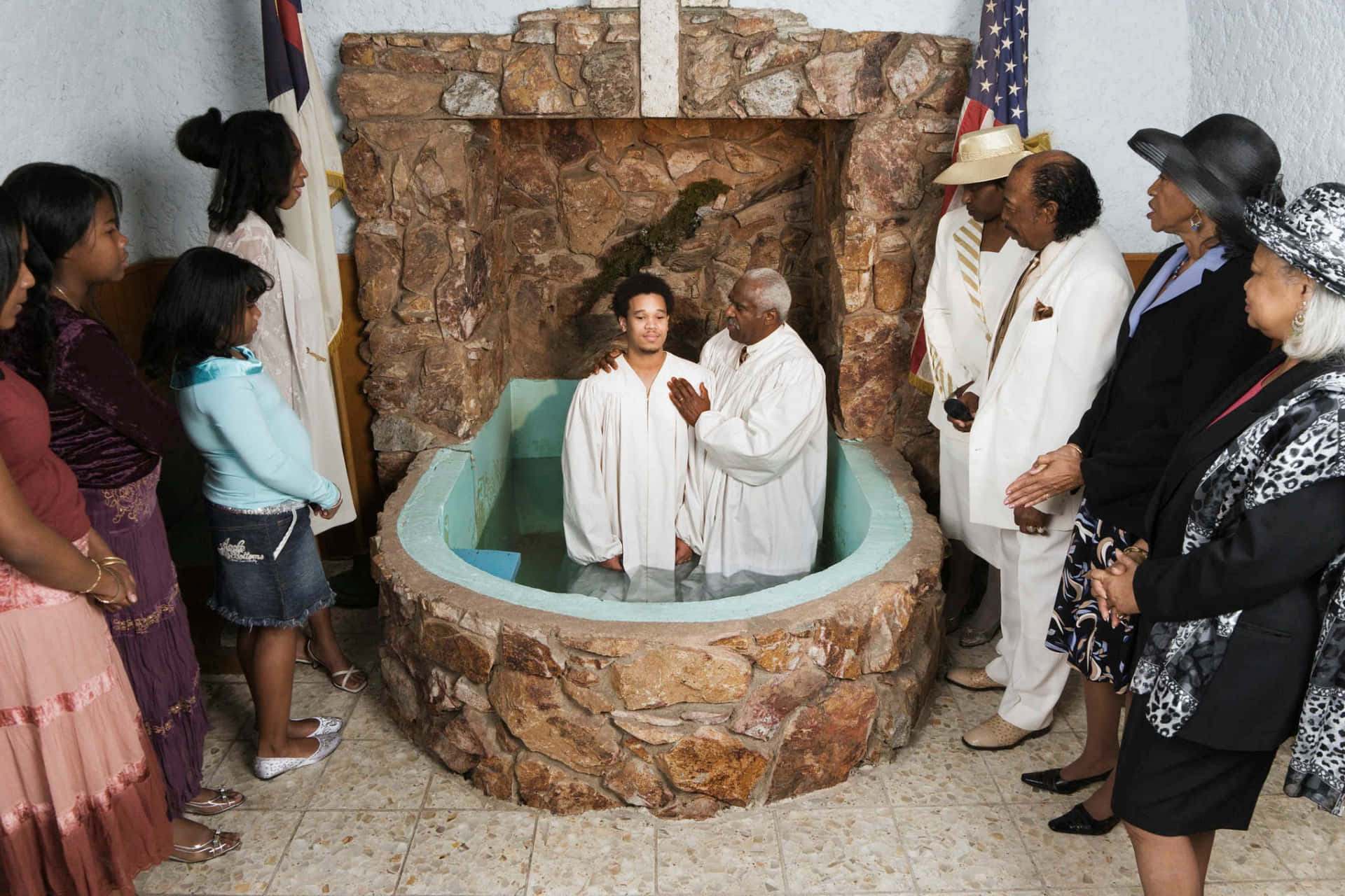 A Group Of People Standing Around A Stone Bathtub