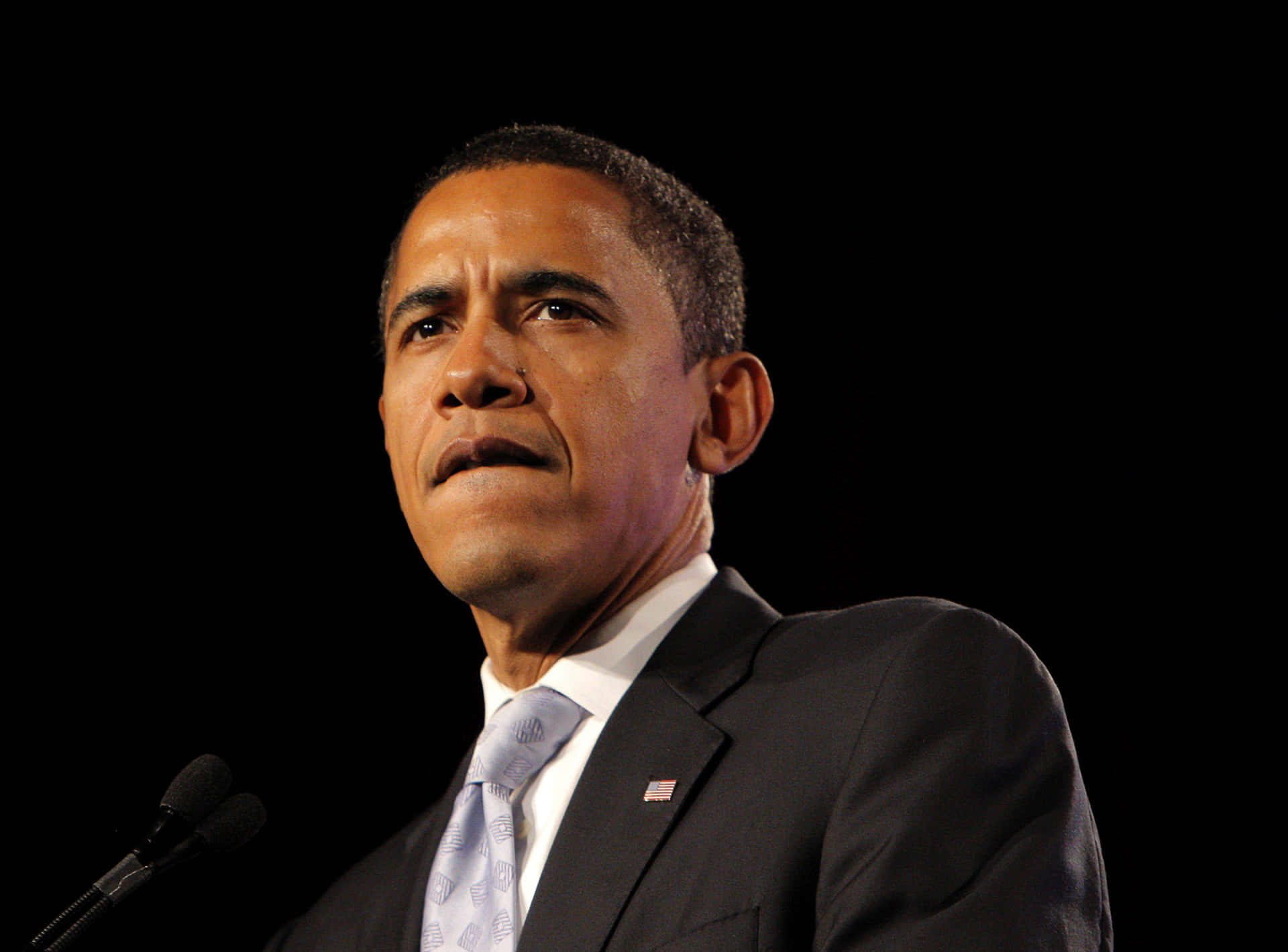 Präsidentbarack Obama Lächelt Und Winkt Während Einer Rede.