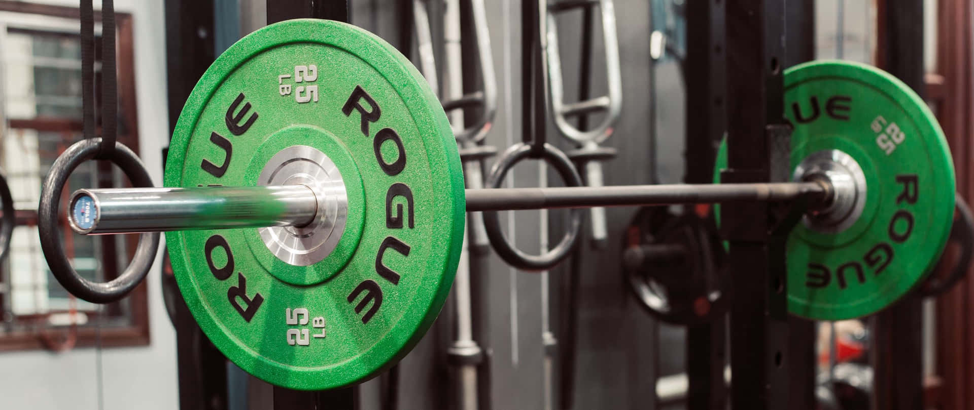 A Green Barbell Hanging On A Barbell Rack