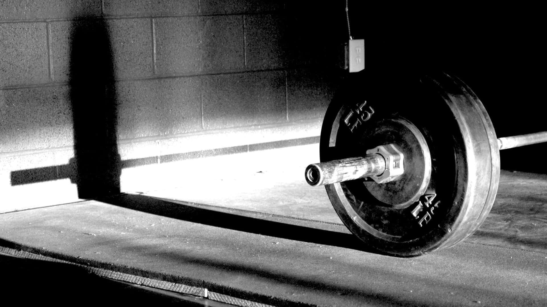 Picking up heavy weights with one hand using a barbell to build strength and power