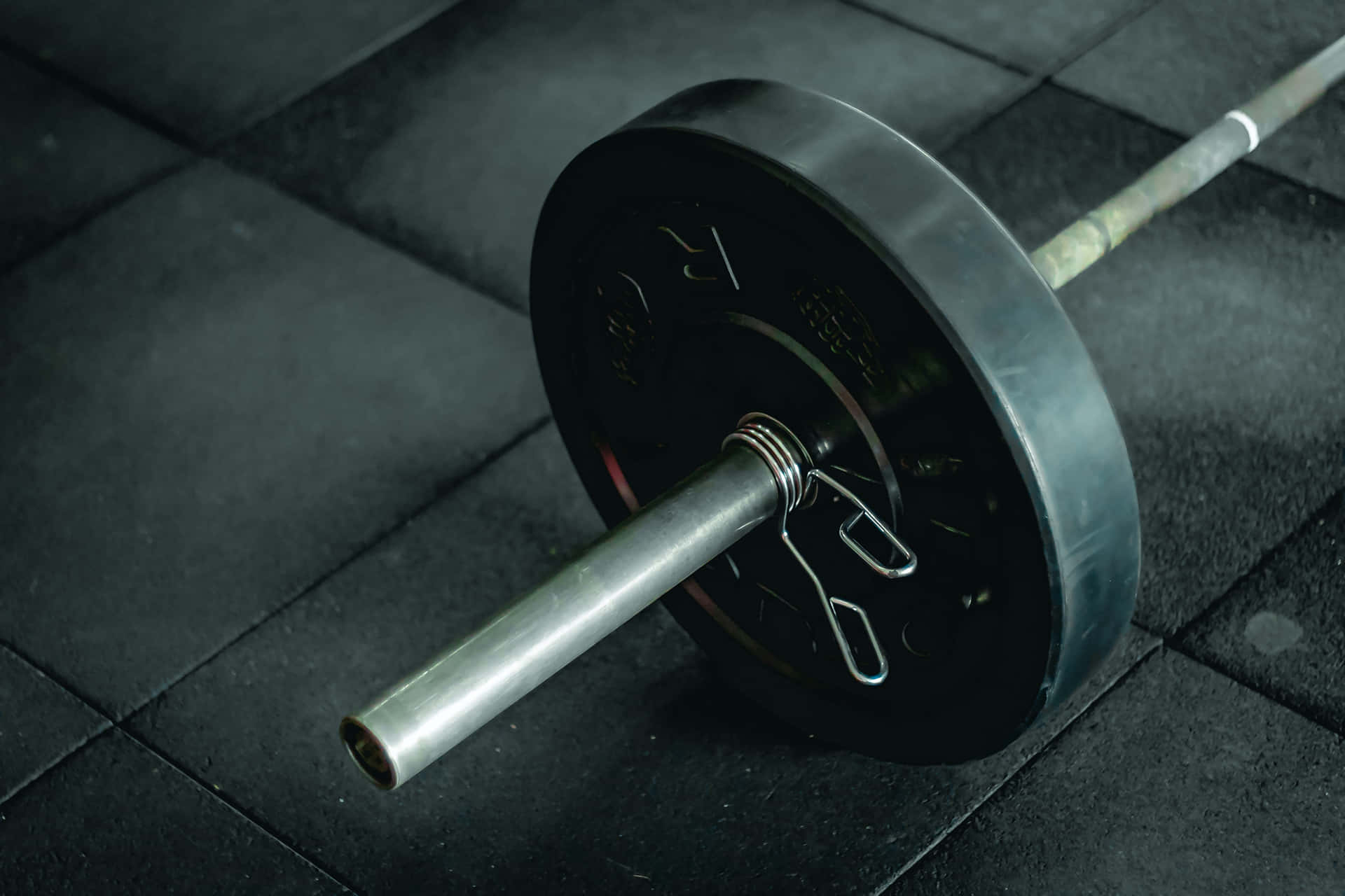 a barbell is sitting on a tile floor