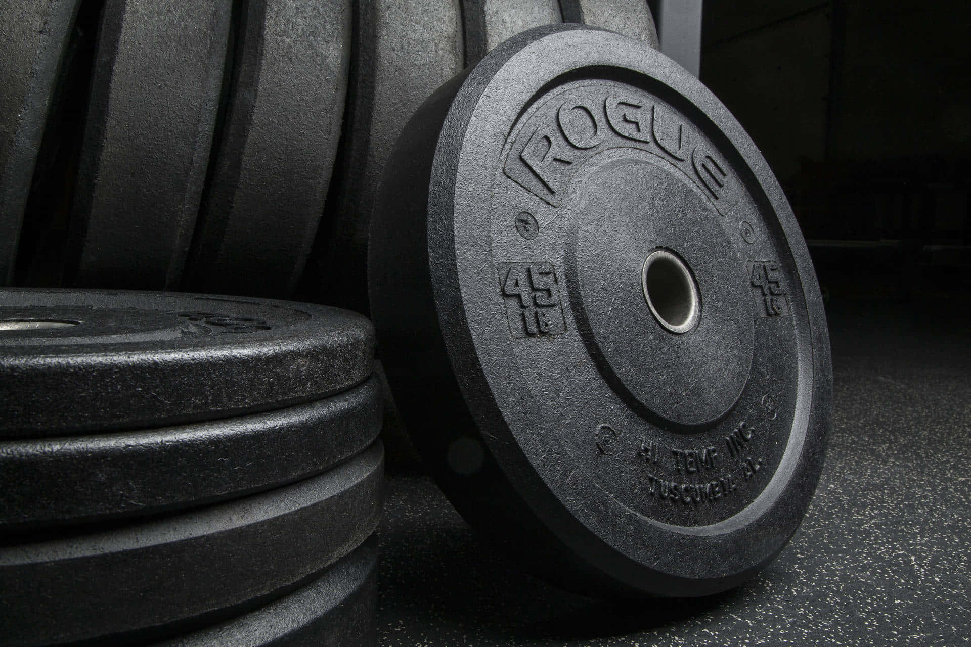 A Pair Of Weight Plates Are Sitting On A Gym Floor