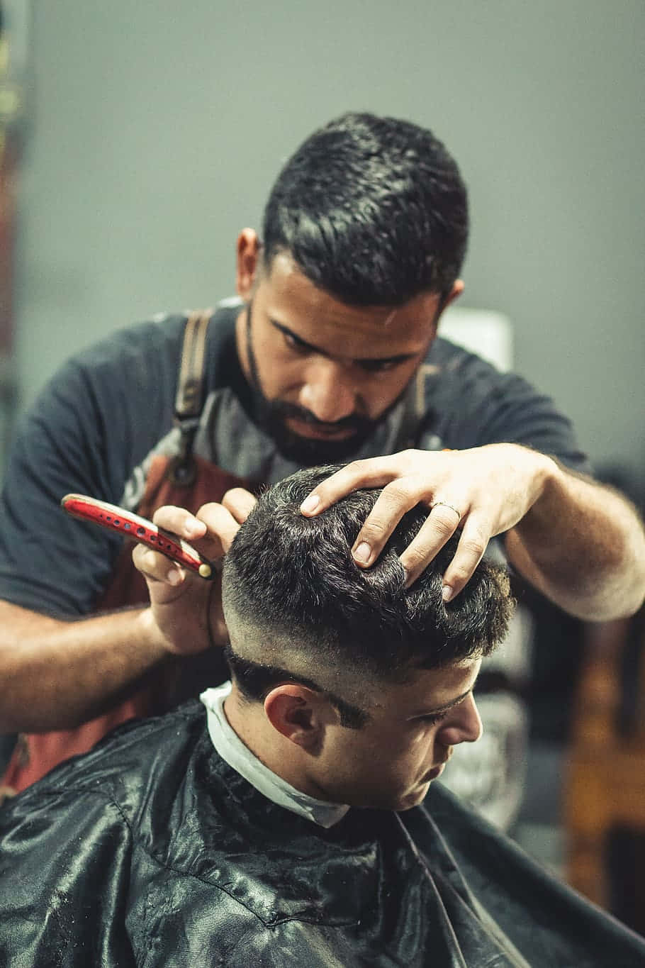 Barber Holding The Head While Cutting The Hair Wallpaper