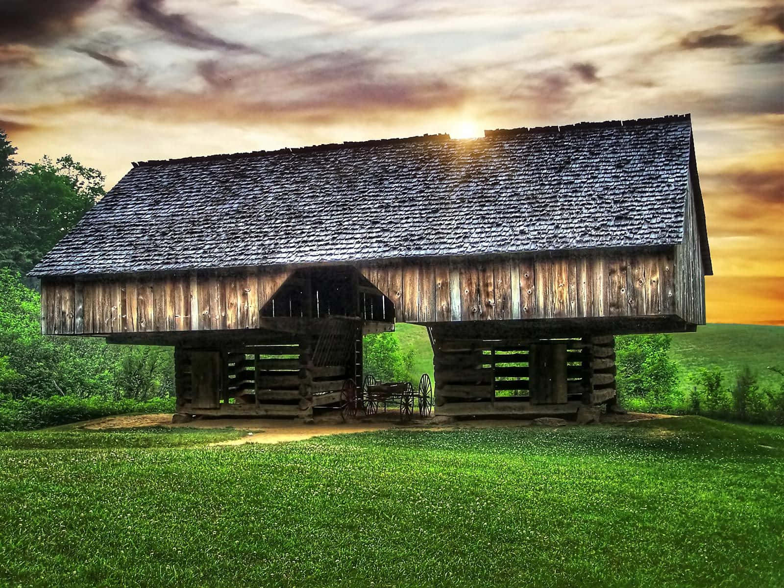 A Wooden Barn Sitting In The Middle Of A Field