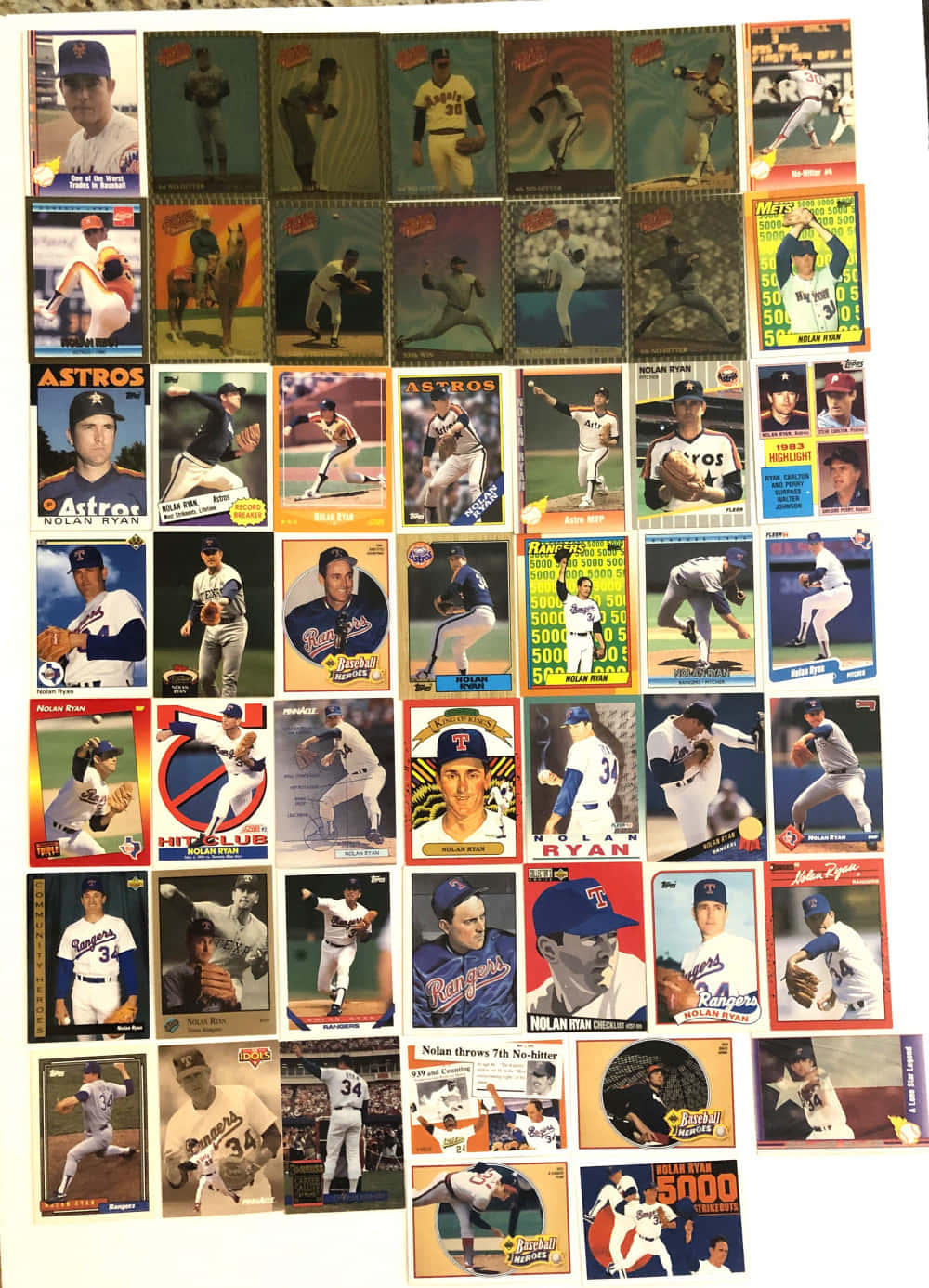 A colorful collection of vintage baseball cards spread across the table. Wallpaper