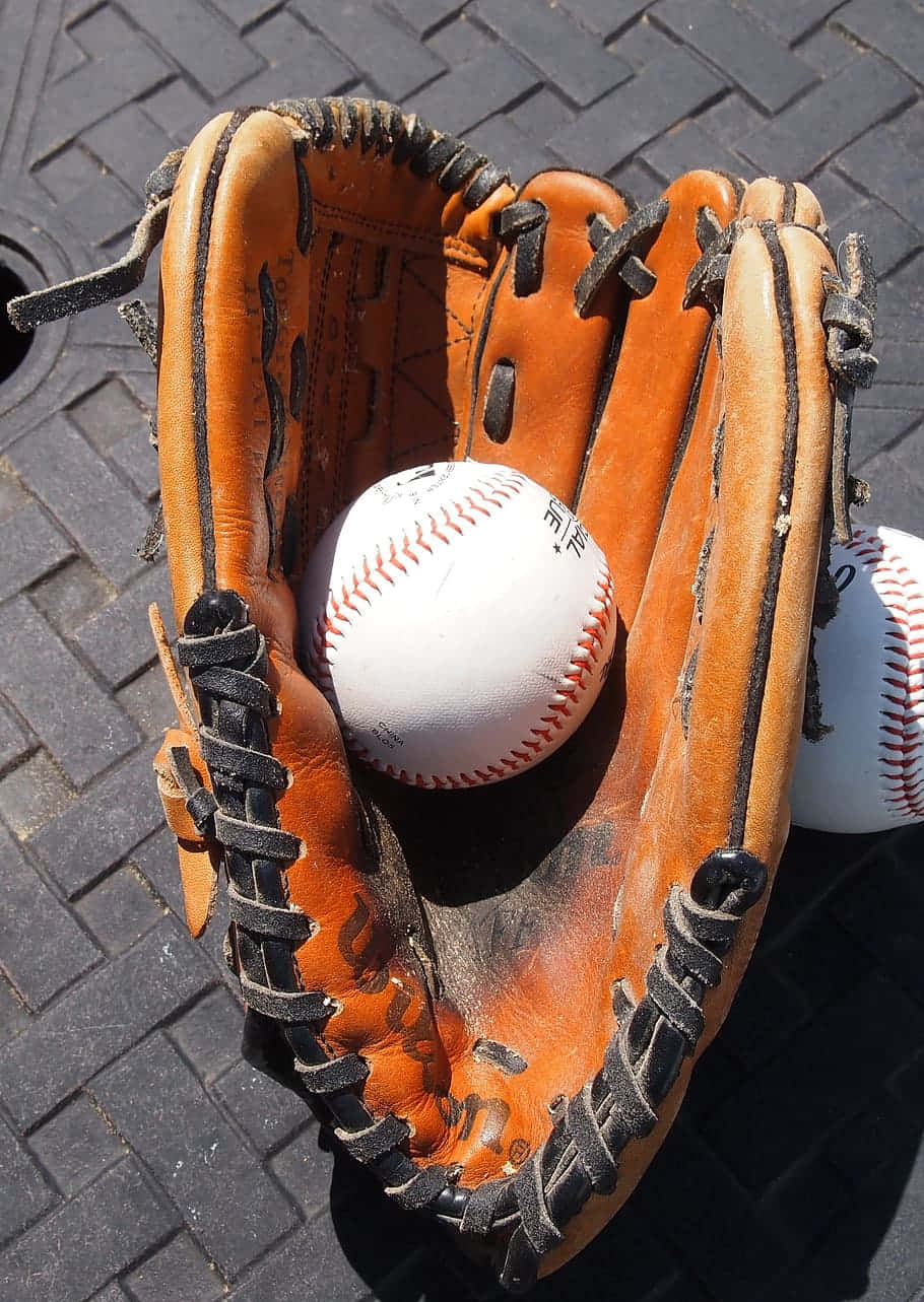 Professional Baseball Gloves Displayed on Field Wallpaper
