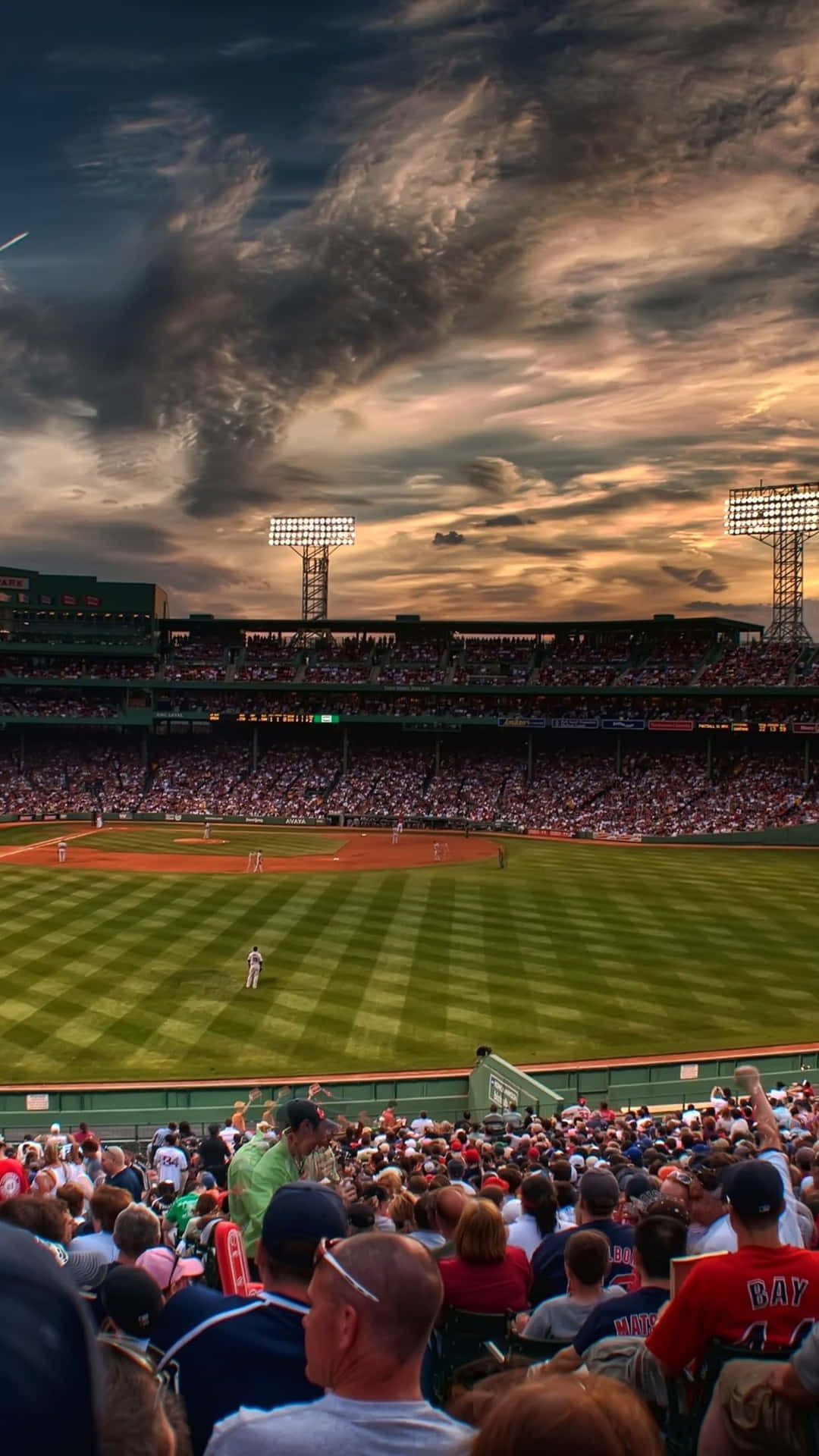 A packed baseball stadium under a mesmerizing sky Wallpaper