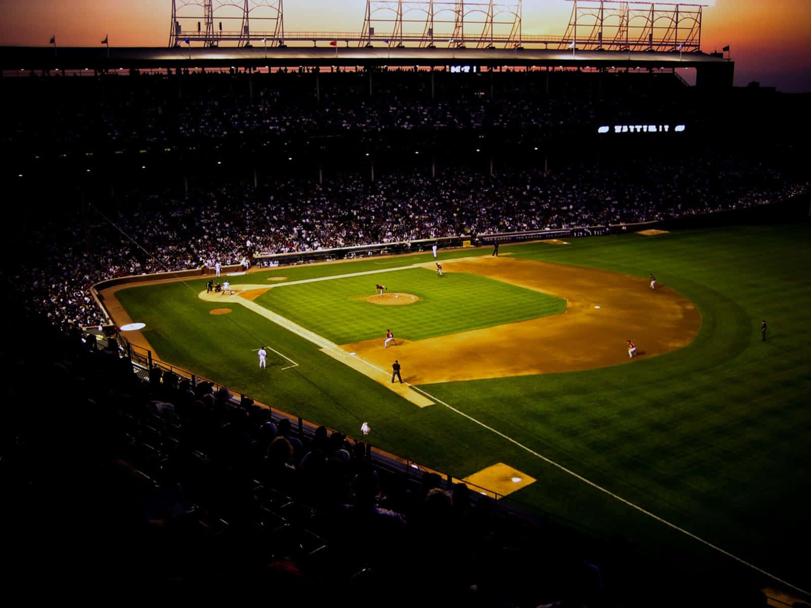 A breathtaking view of a baseball stadium packed with cheering fans Wallpaper