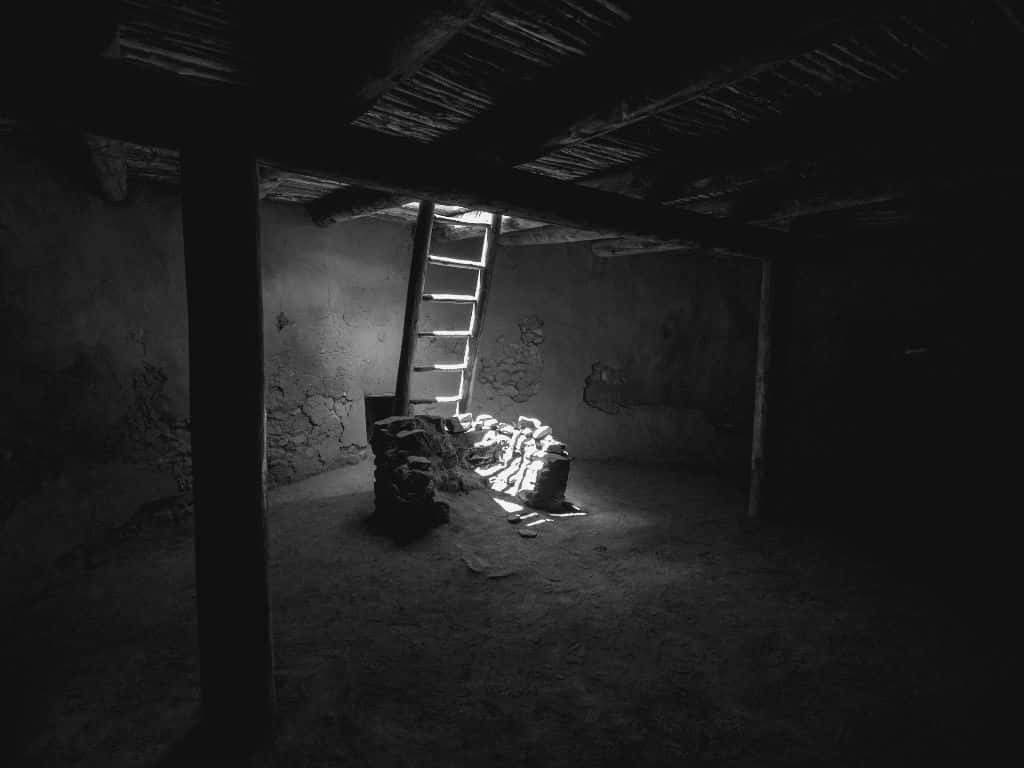 A Ladder In A Dark Room With A Light On It