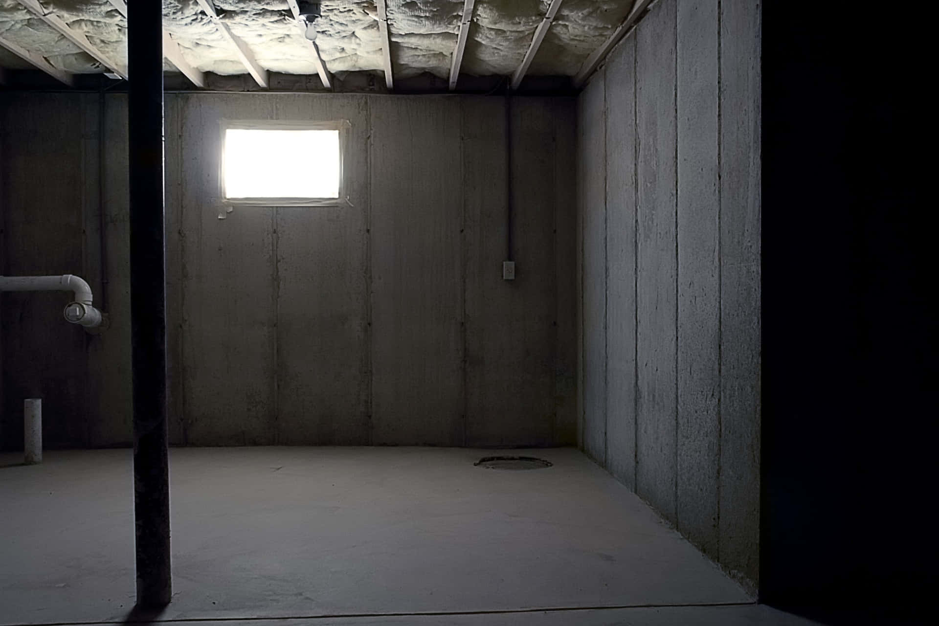 A Bathroom With A Window And Concrete Walls