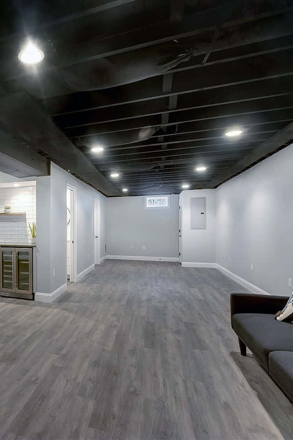 A Basement With Wood Floors And A Couch