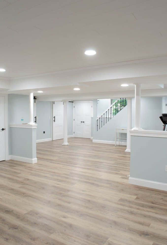 A Basement With White Walls And Wood Floors