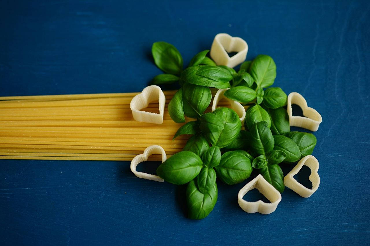 Fresh Basil Leaves with Spaghetti Pasta in a Kitchen Setting Wallpaper