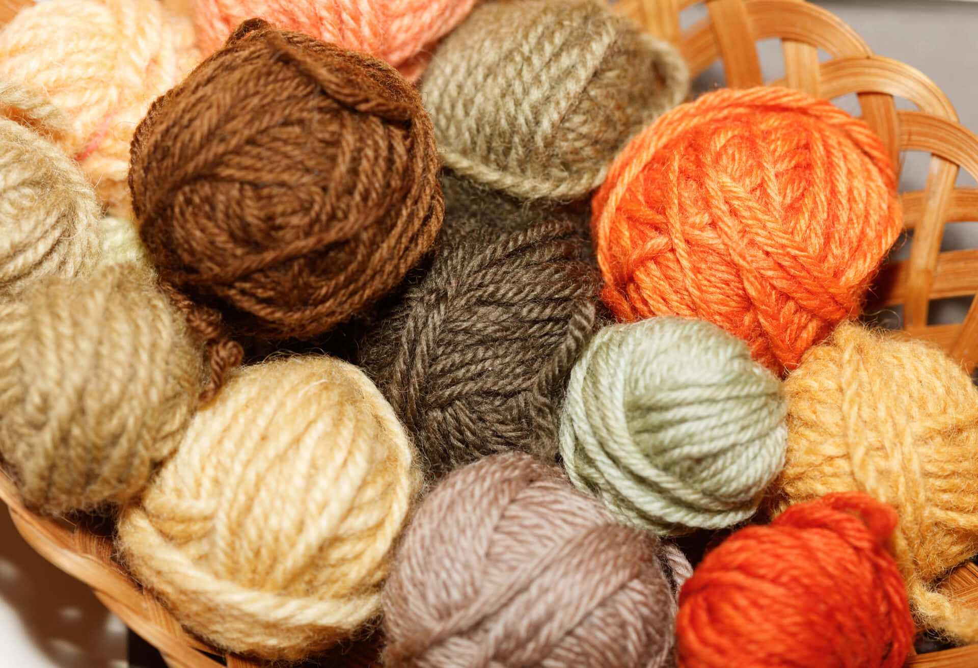 A vibrant basketful of multicolored knitting yarns Wallpaper