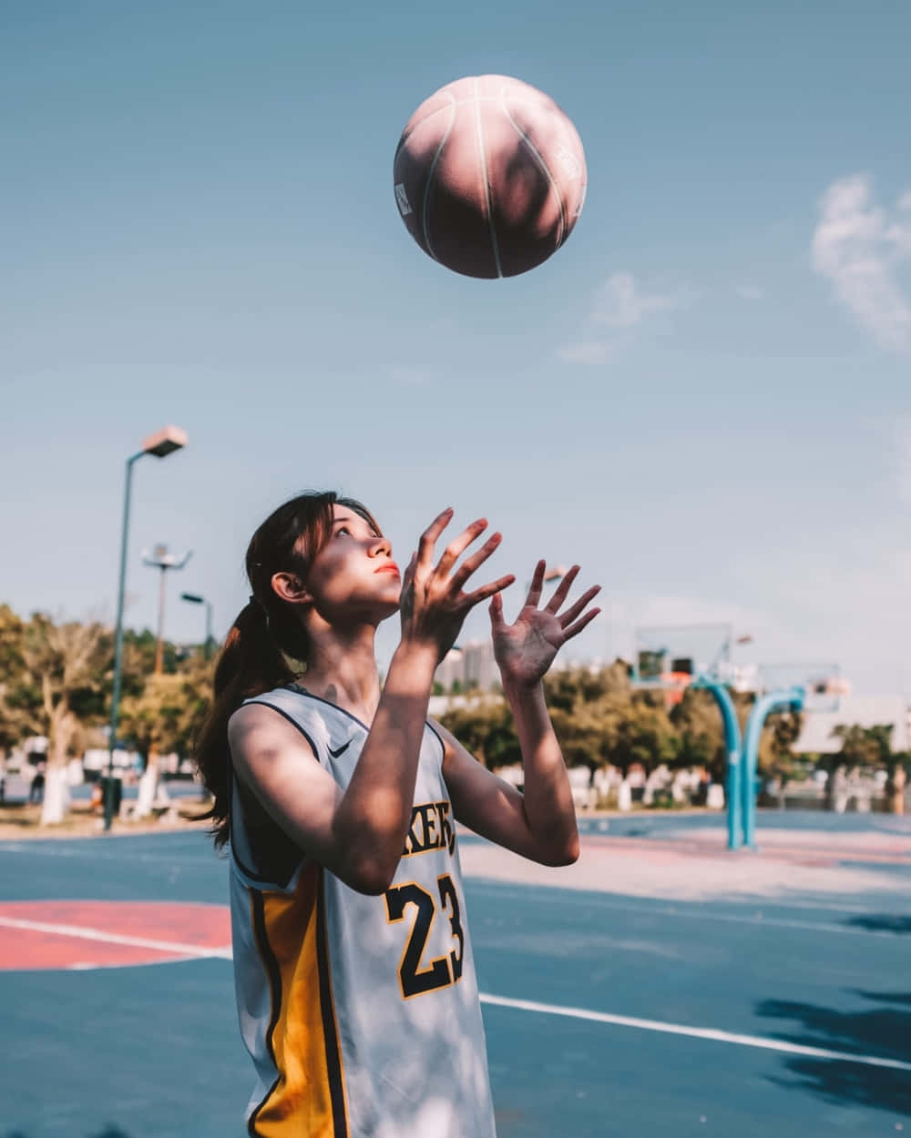 Basketball Girl Catching Ball Outdoor Court.jpg Wallpaper