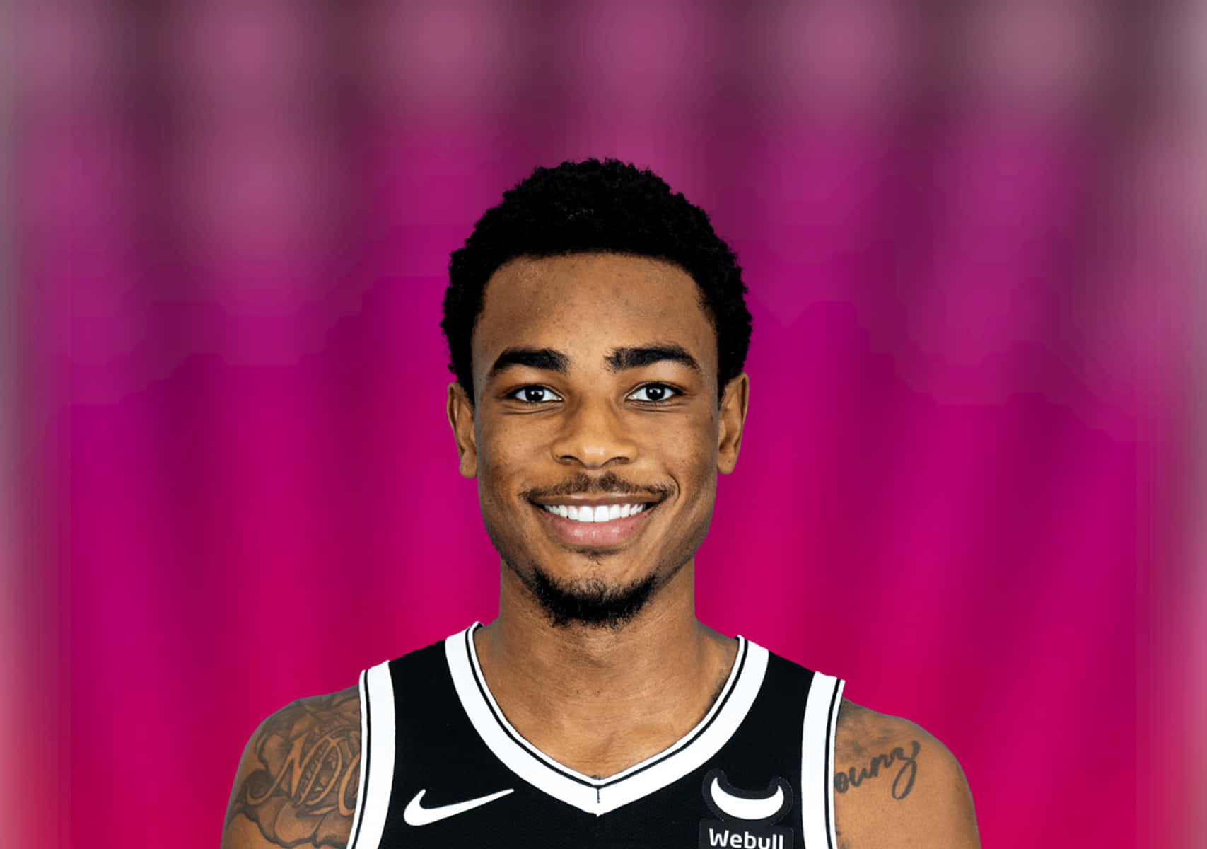 Basketball Player Smiling Against Pink Background Wallpaper